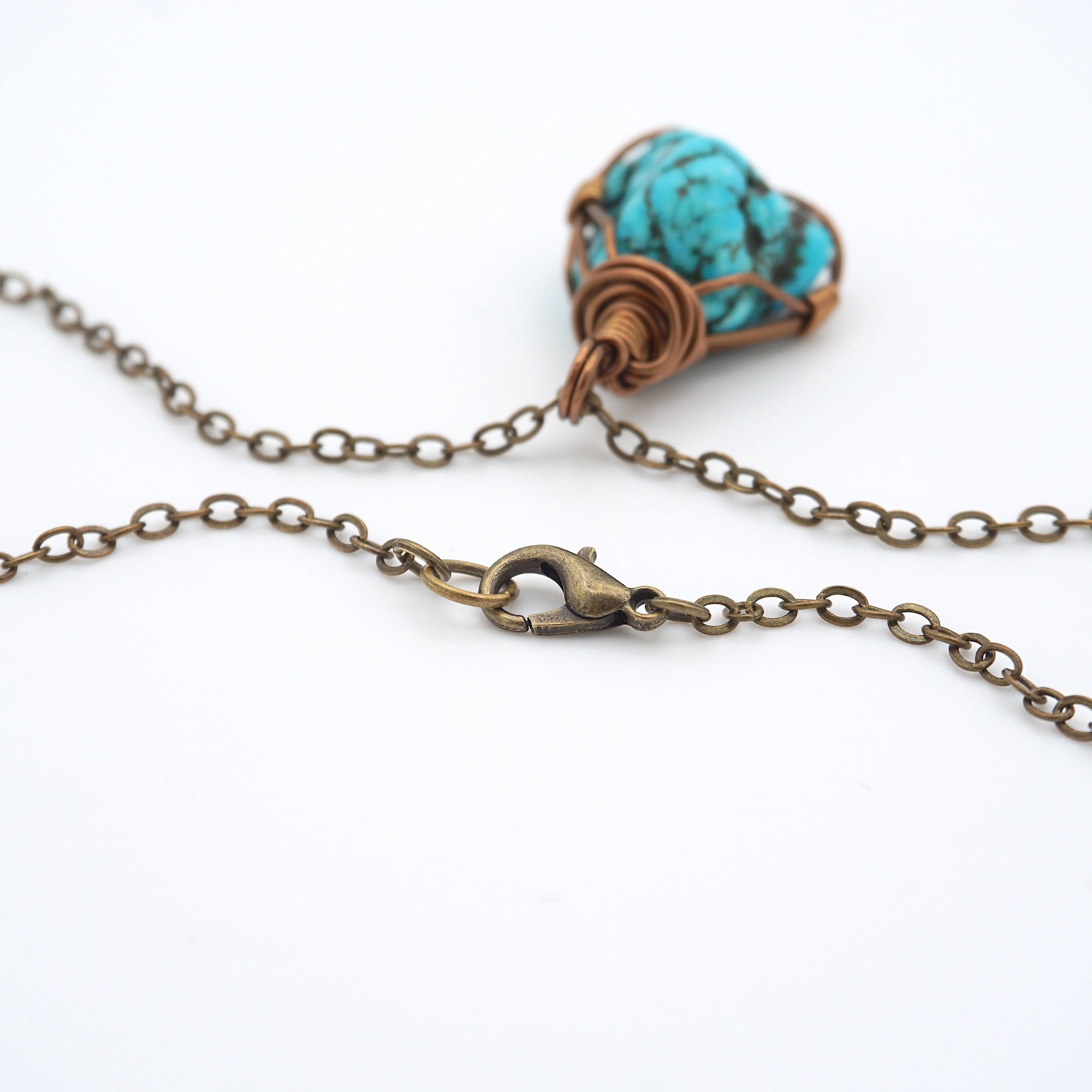Close up of antique bronze chain clasp for raw turquoise necklace, quality hardware detail