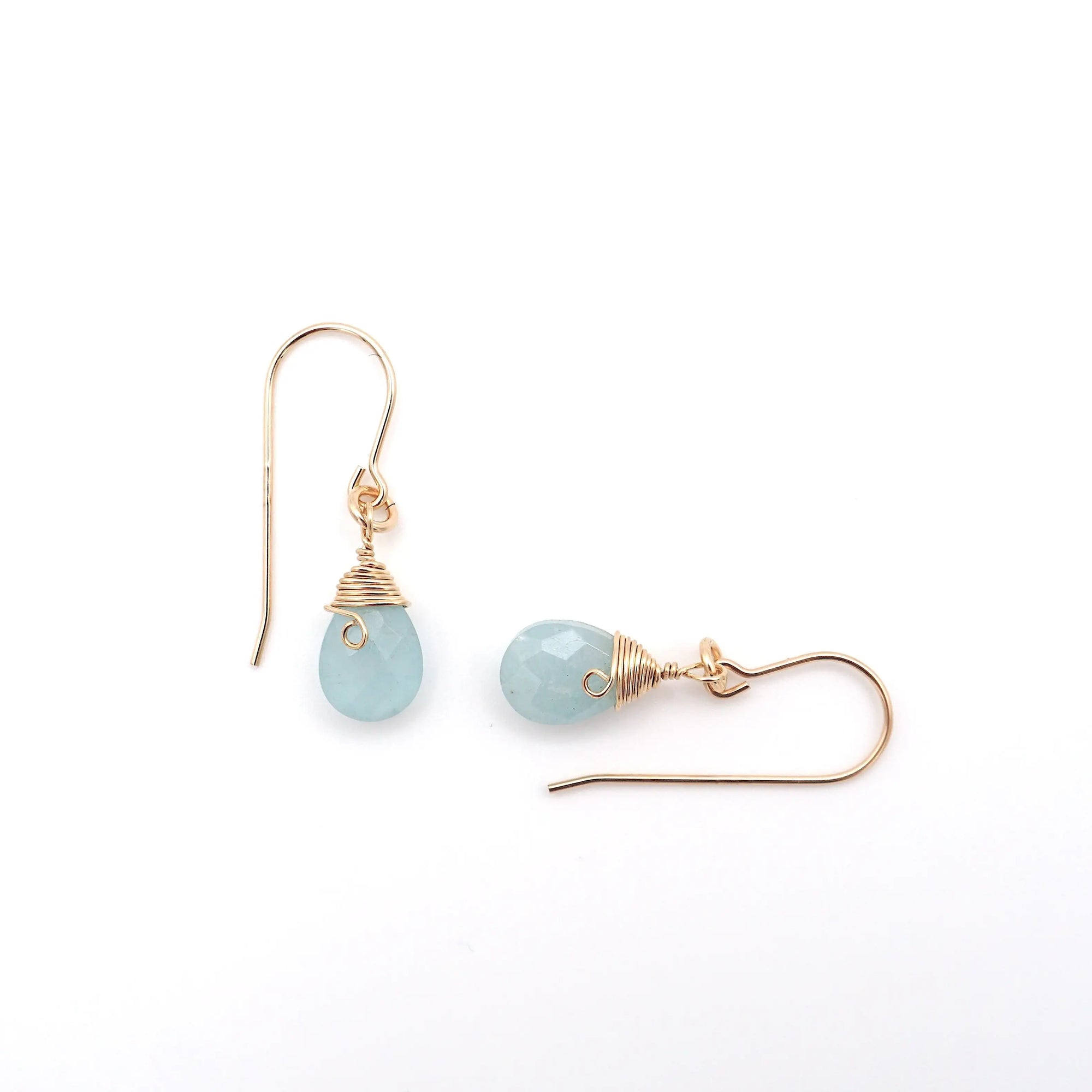 Close-up of 14k gold filled aquamarine drop earrings, focusing on faceted gemstone and artisan wire wrapping