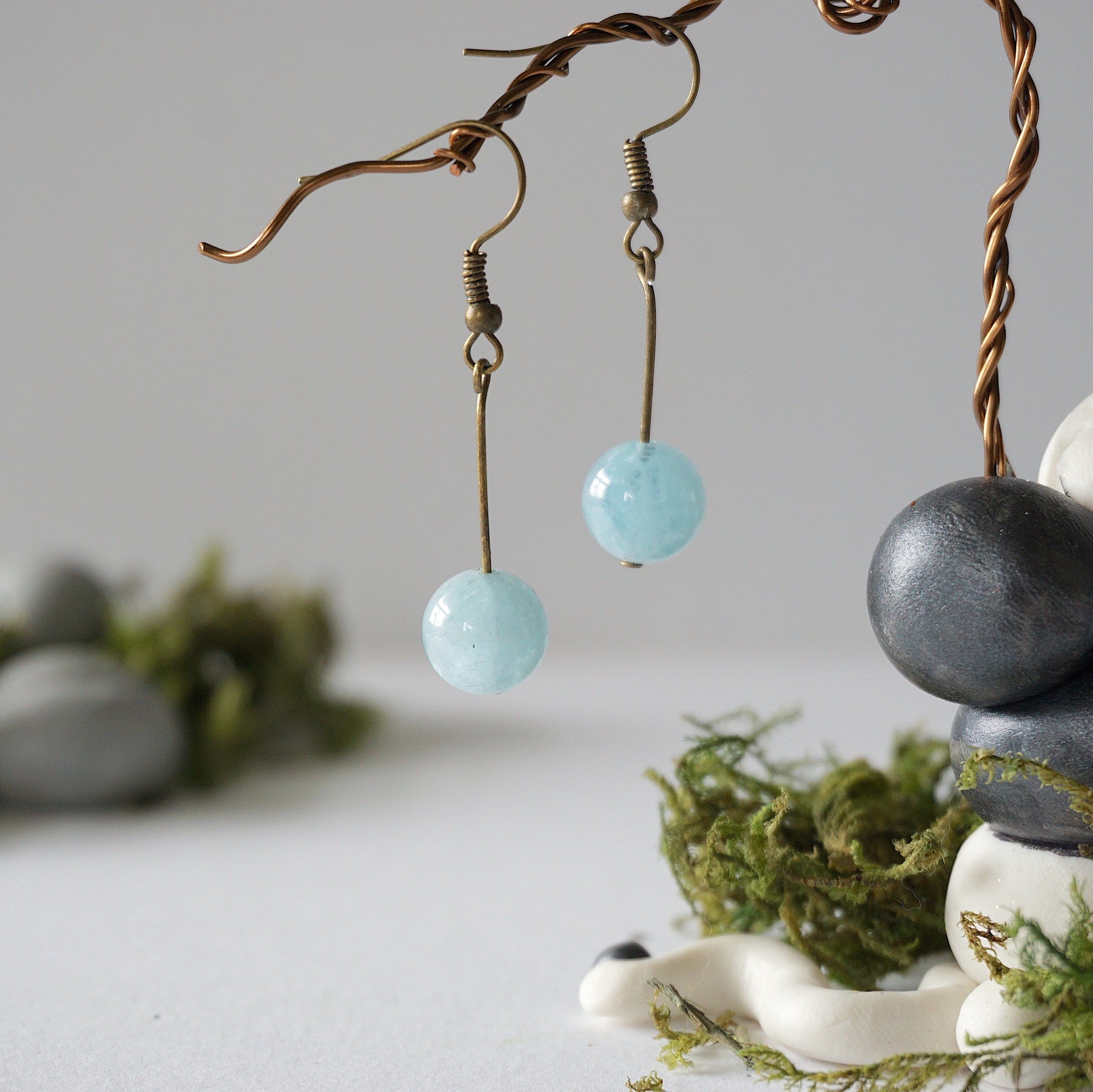 Minimalist aquamarine drop earrings on display, front view, genuine gemstone, antique bronze finish, Designs by Nature Gems