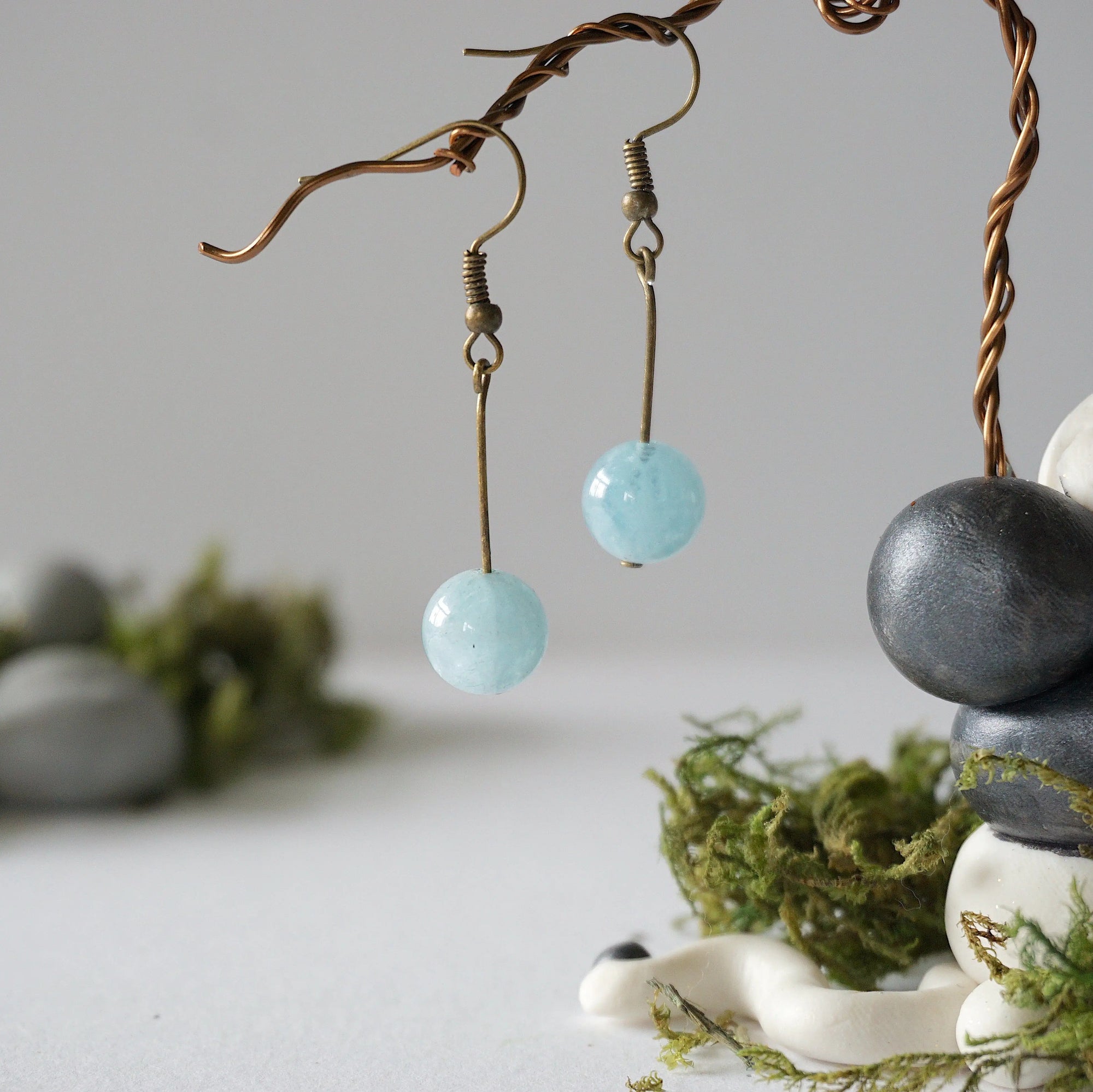 Minimalist aquamarine drop earrings on display, front view, genuine gemstone, antique bronze finish, Designs by Nature Gems