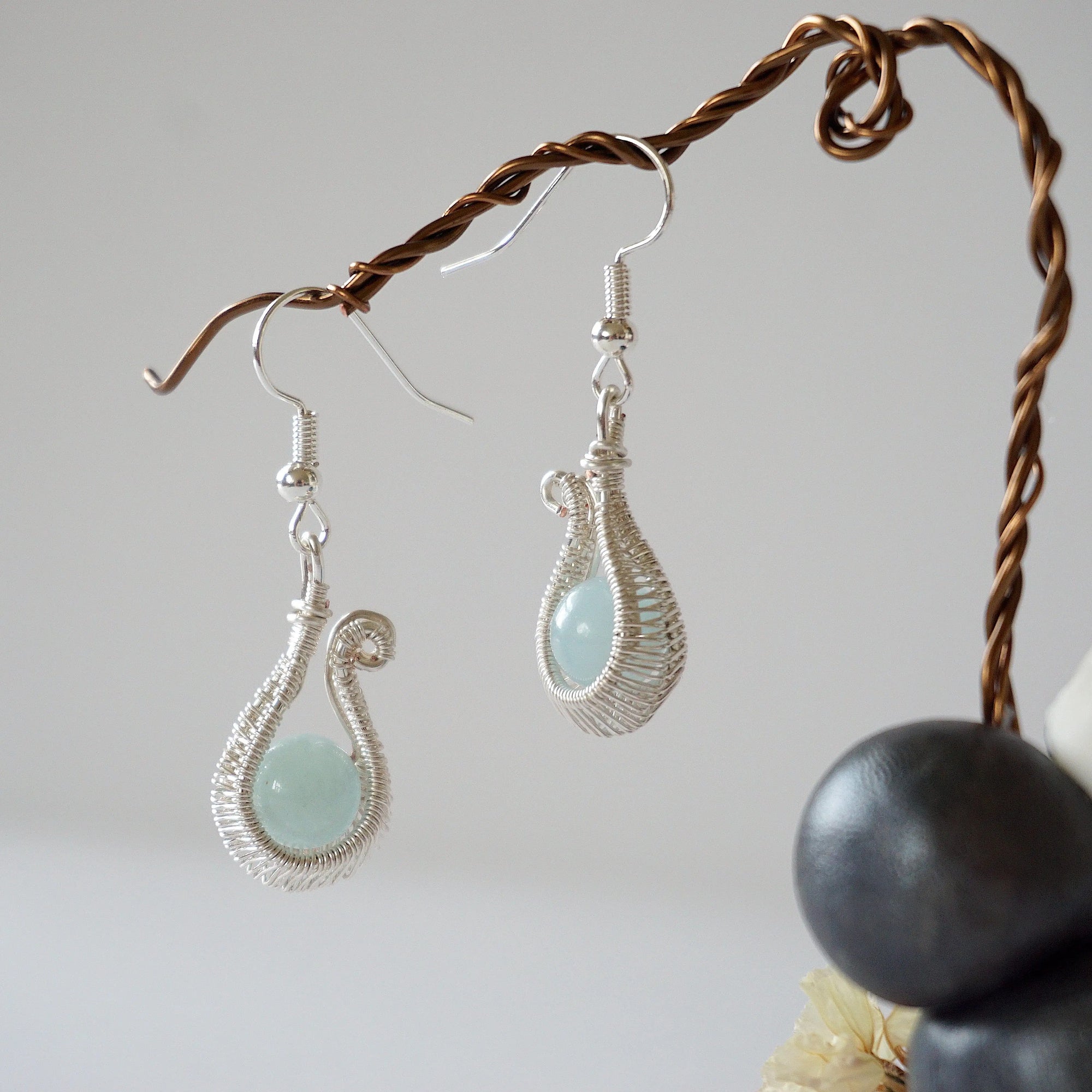 Another angle of aquamarine drop earrings highlighting detailed wire artistry and genuine aquamarine bead
