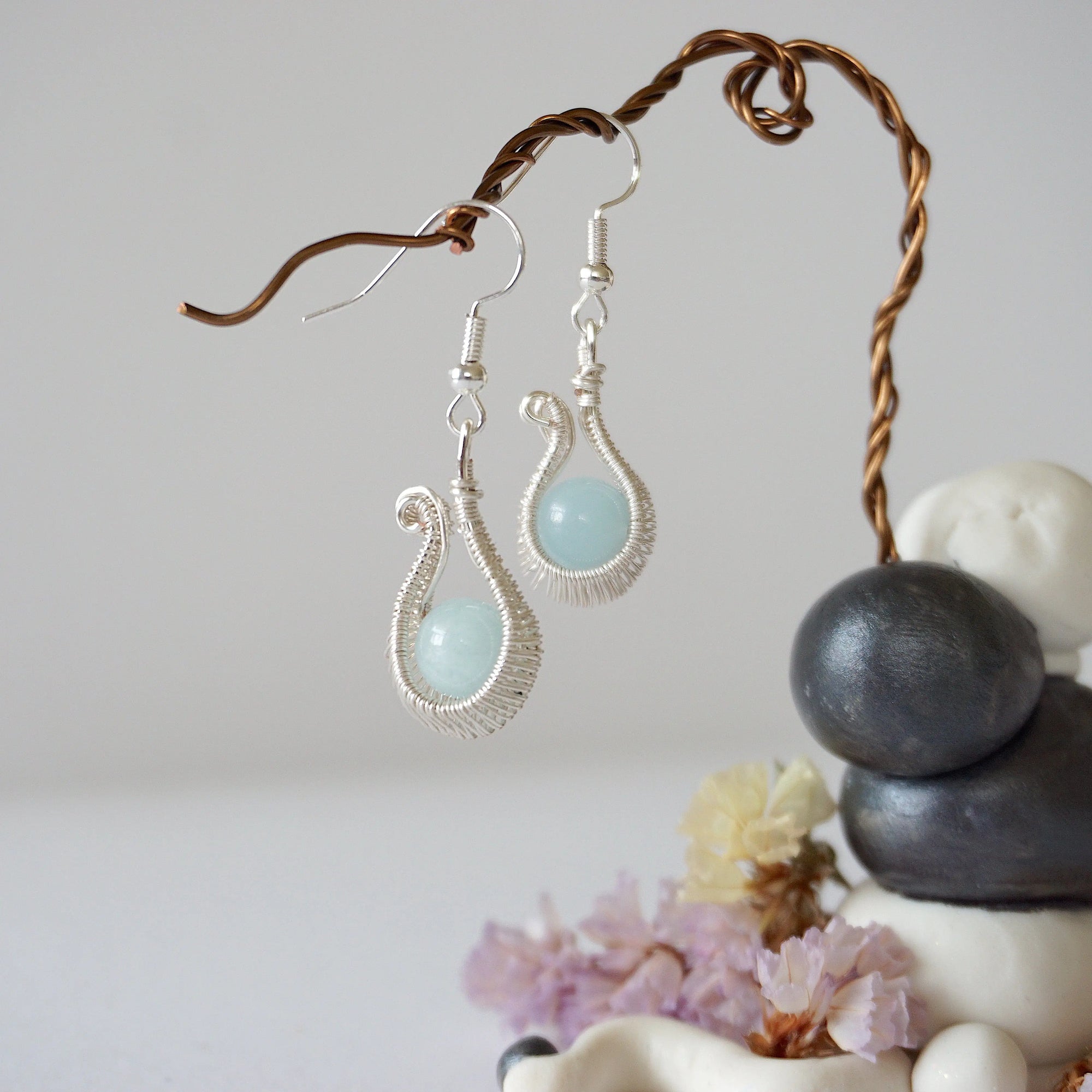 Side angle view of aquamarine drop earrings, showing intricate wire wrapping and soft silver finish, March birthstone