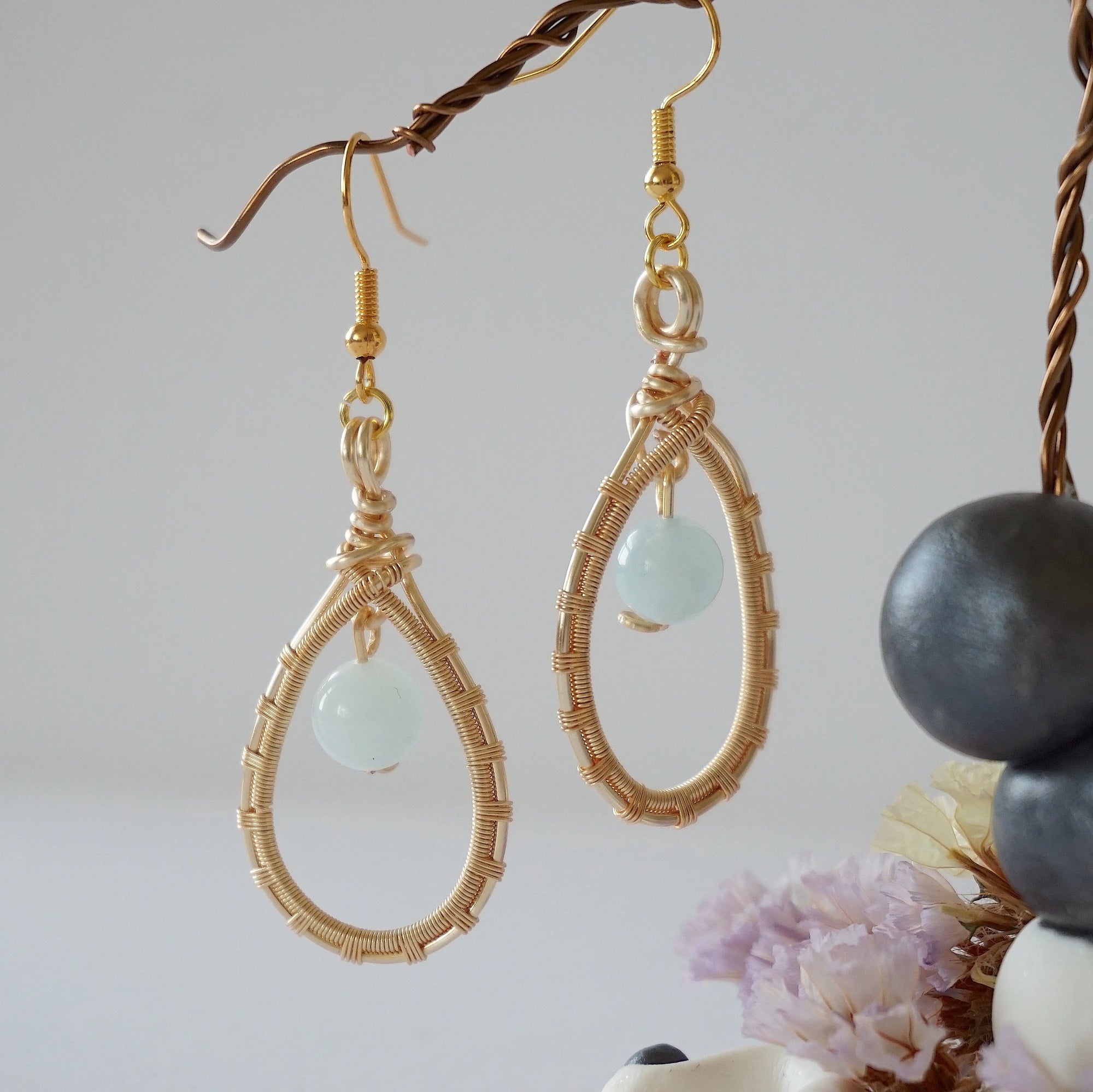 Another angle of aquamarine drop earrings highlighting detailed wire artistry and genuine aquamarine bead, warm gold finish