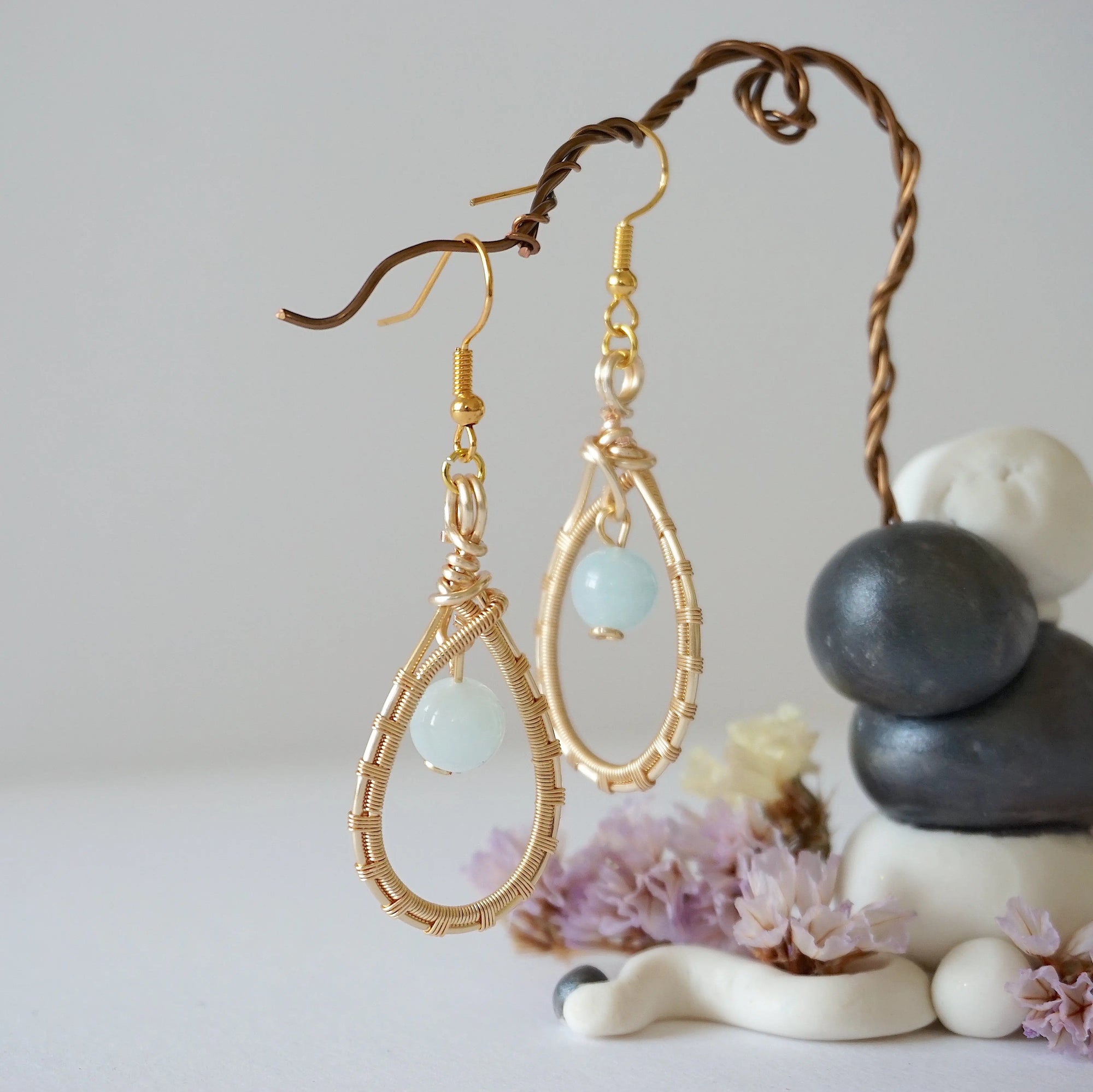 Side angle view of aquamarine drop earrings, showing intricate wire wrapping and warm gold finish, March birthstone