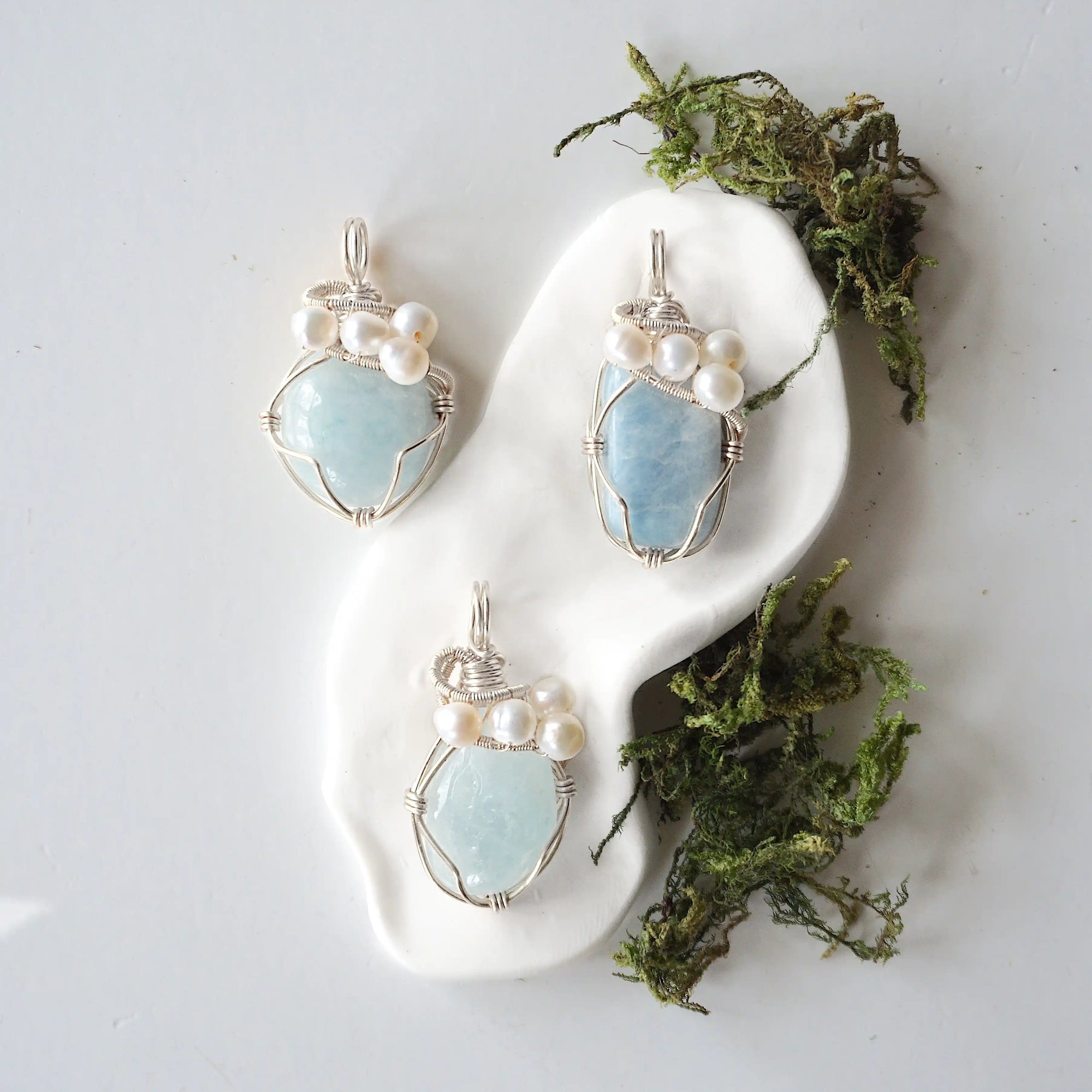 Three silver wire wrapped aquamarine and freshwater pearl pendants showing natural stone variation, artisan jewelry for women