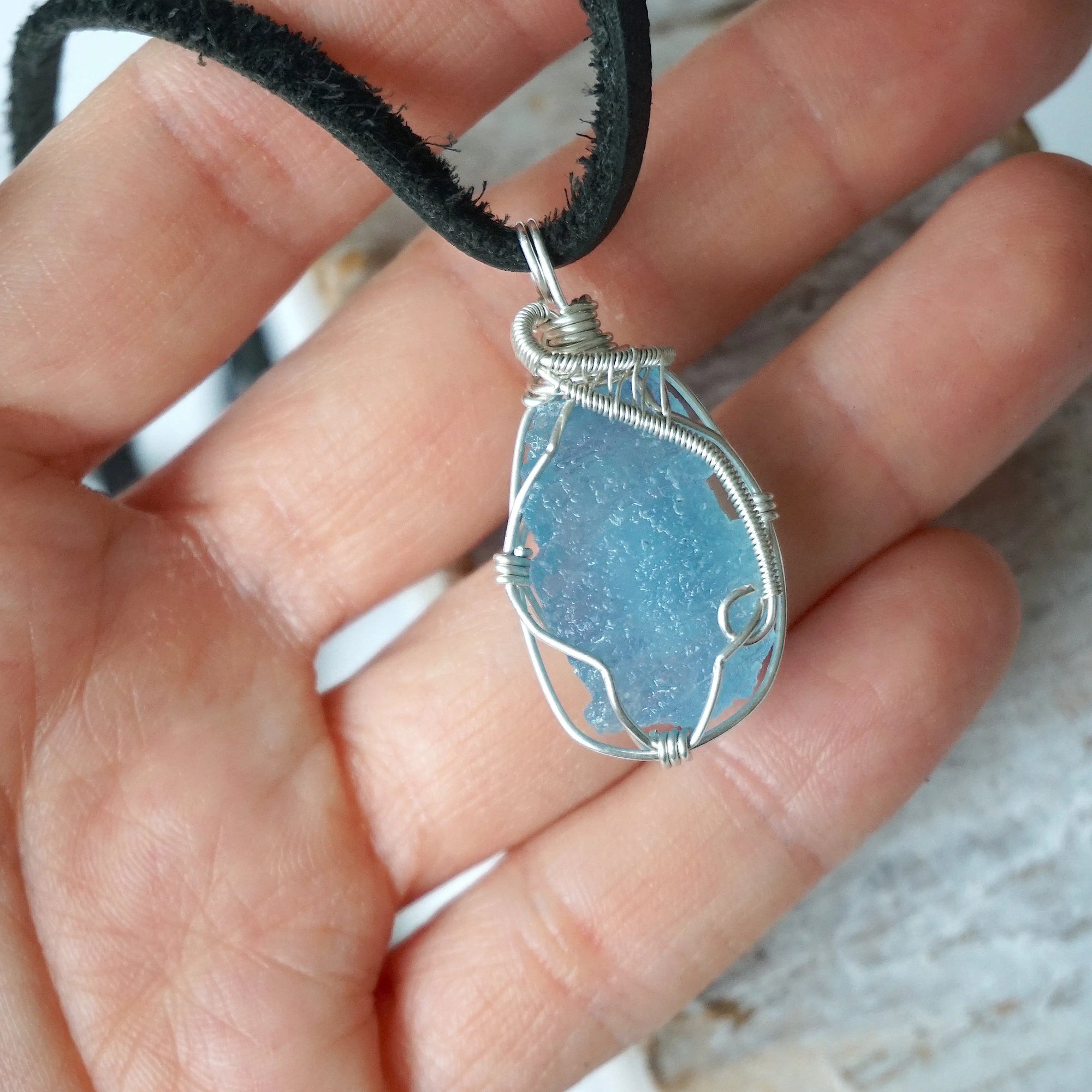 Raw aquamarine necklace in hand for size reference, artisan wire wrapped, 925 sterling silver, men's necklace