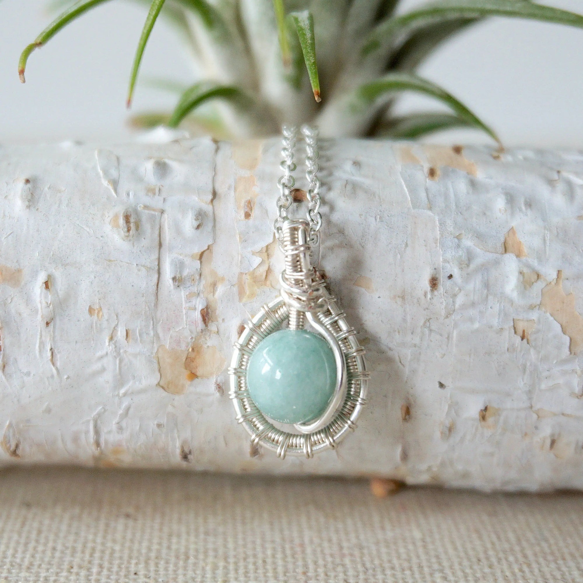 Back angle of aquamarine necklace, showing wire wrapped setting and fine silver plated chain