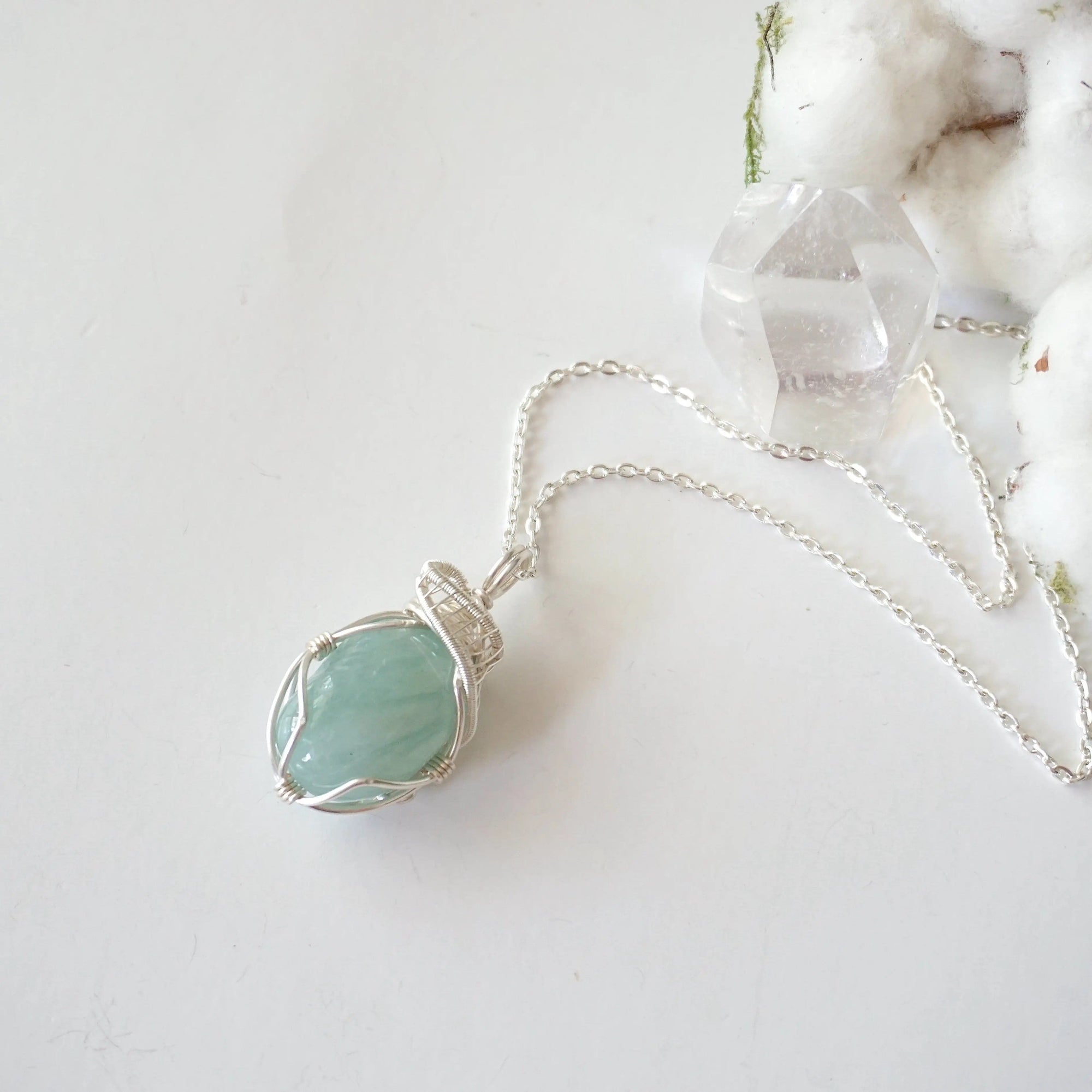 Aquamarine pendant necklace for women on a silver chain laying flat, artisan wire wrapped, soft silver over copper, Designs by Nature Gems