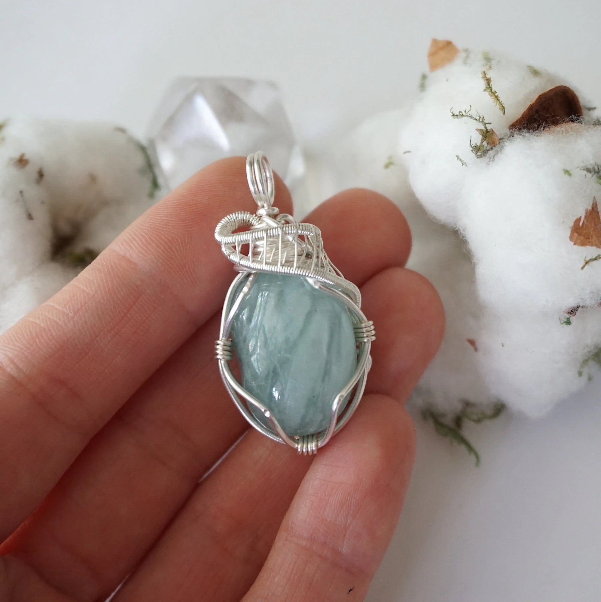 Aquamarine pendant in hand for size reference, genuine polished raw aquamarine, soft silver over copper wire wrapping