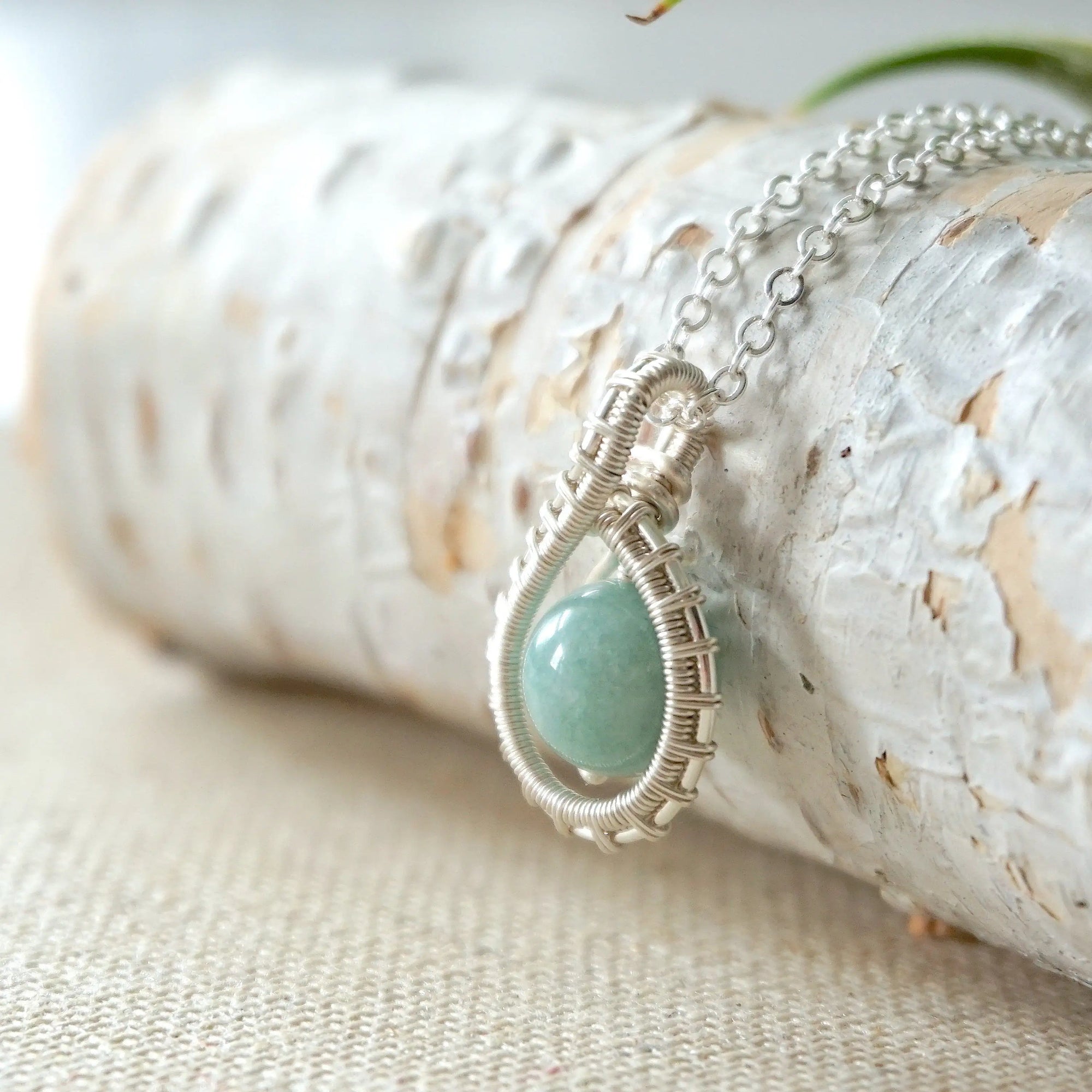 Left side angle of aquamarine necklace for women, detailed wire wrapping, soft silver finish