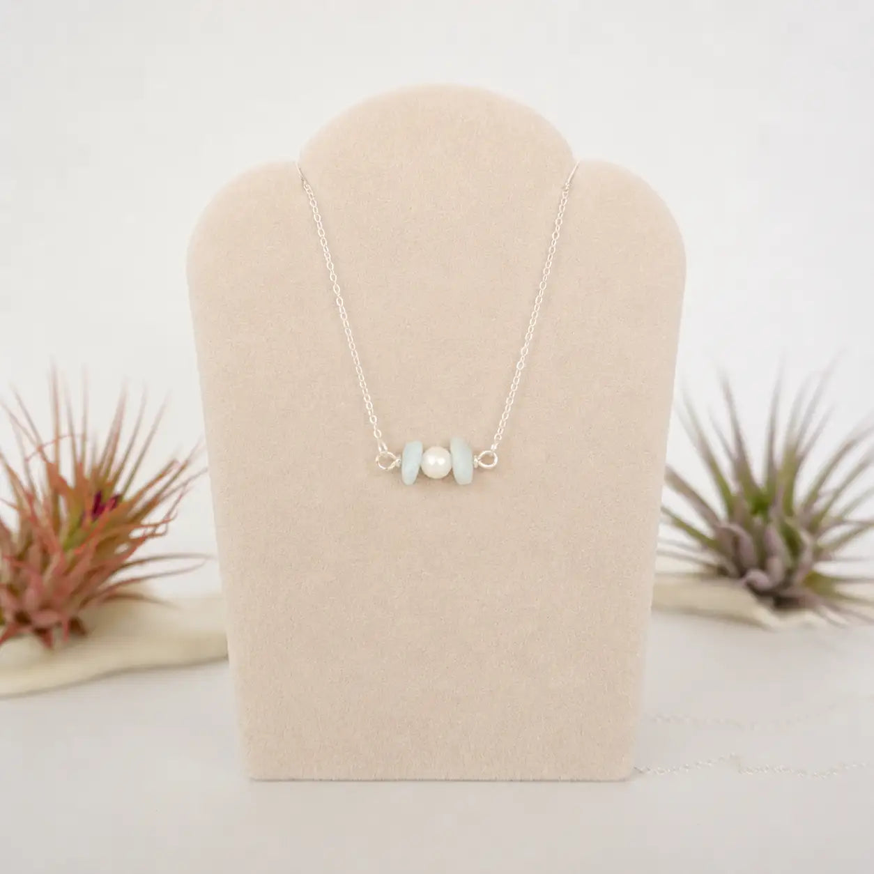 Aquamarine and freshwater pearl bar necklace in 925 sterling silver on jewelry display, front view