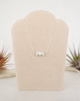 Aquamarine and freshwater pearl bar necklace in 925 sterling silver on jewelry display, front view