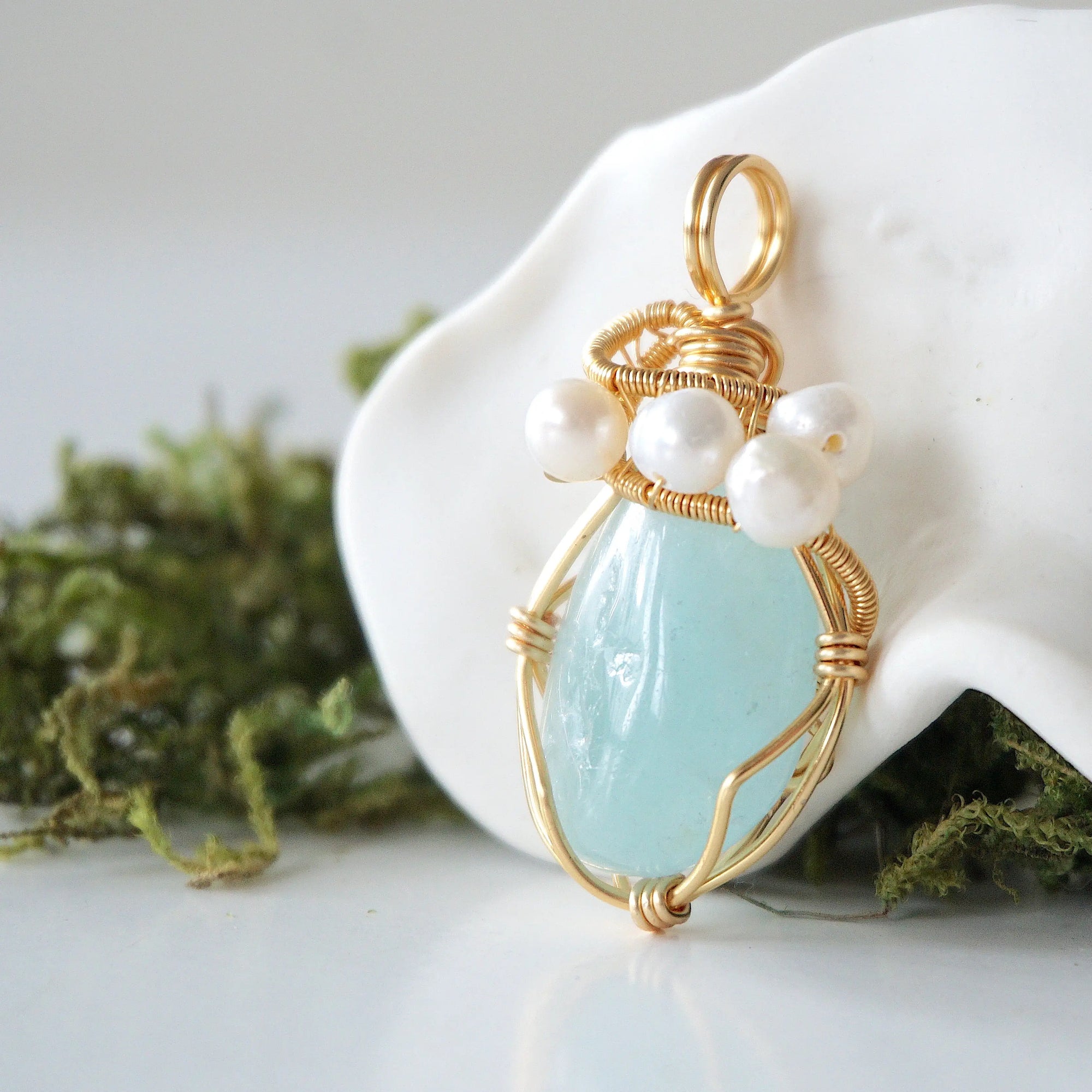 Side angle detail of aquamarine and freshwater pearl pendant, gold wire wrapped, ethical artisan necklace