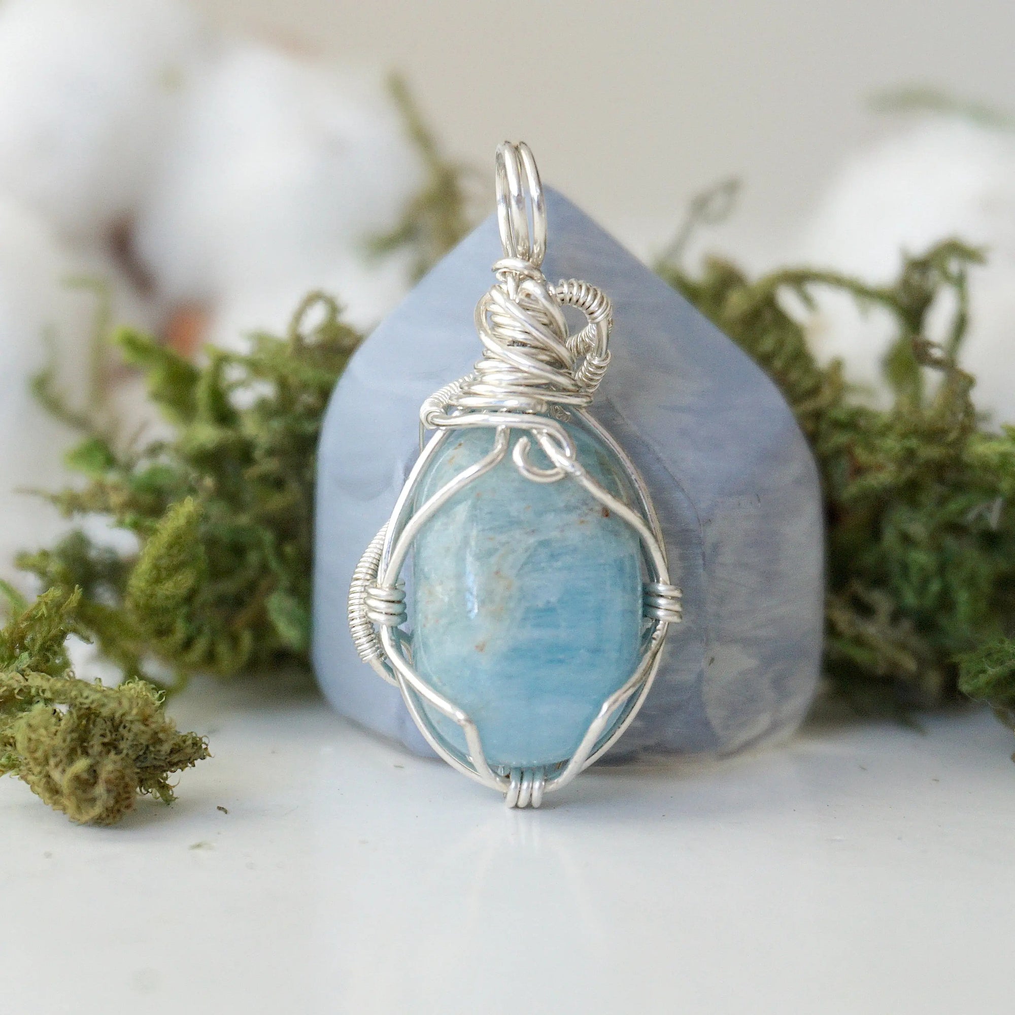 Back view of aquamarine pendant, genuine polished stone with handcrafted silver wire
