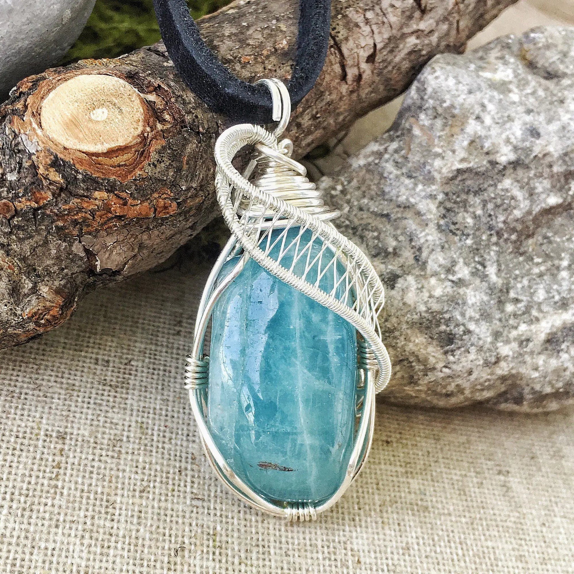 Close-up of polished aquamarine pendant front, artisan wire wrapped in 925 sterling silver, men's necklace
