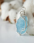 Side view of raw aquamarine pendant showing detailed artisan wire wrapping in sterling silver