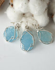 Three raw aquamarine pendants showing natural variation in size, shape, and blue color, Designs by Nature Gems