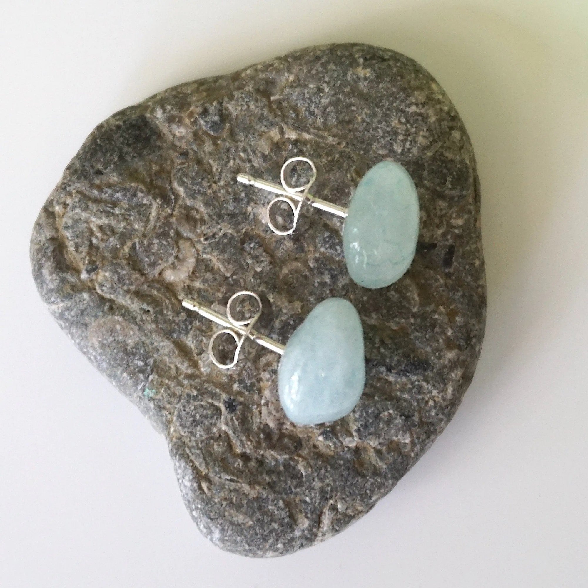Top angle of aquamarine stud earrings with sterling silver posts, showing raw stone texture