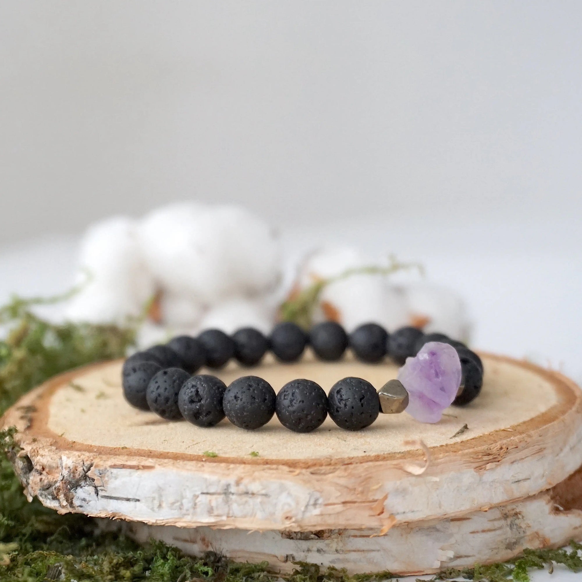 Right side angle of unisex black lava beaded bracelet featuring raw amethyst and pyrite accents