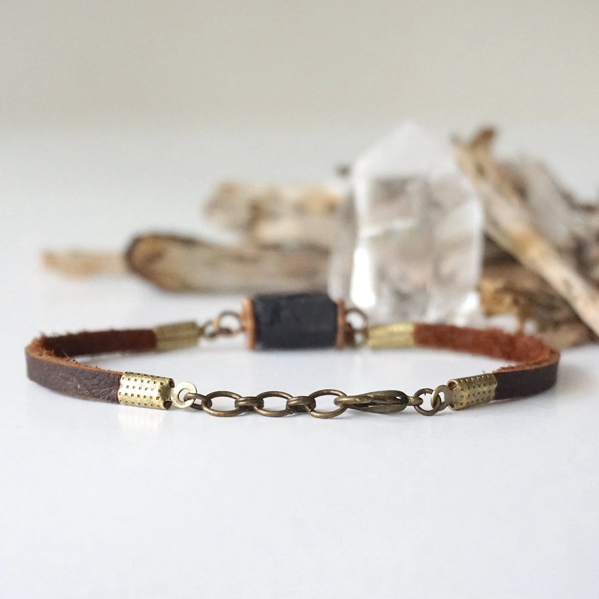 Lobster clasp and adjustable bronze chain extension on a men’s black tourmaline leather bracelet