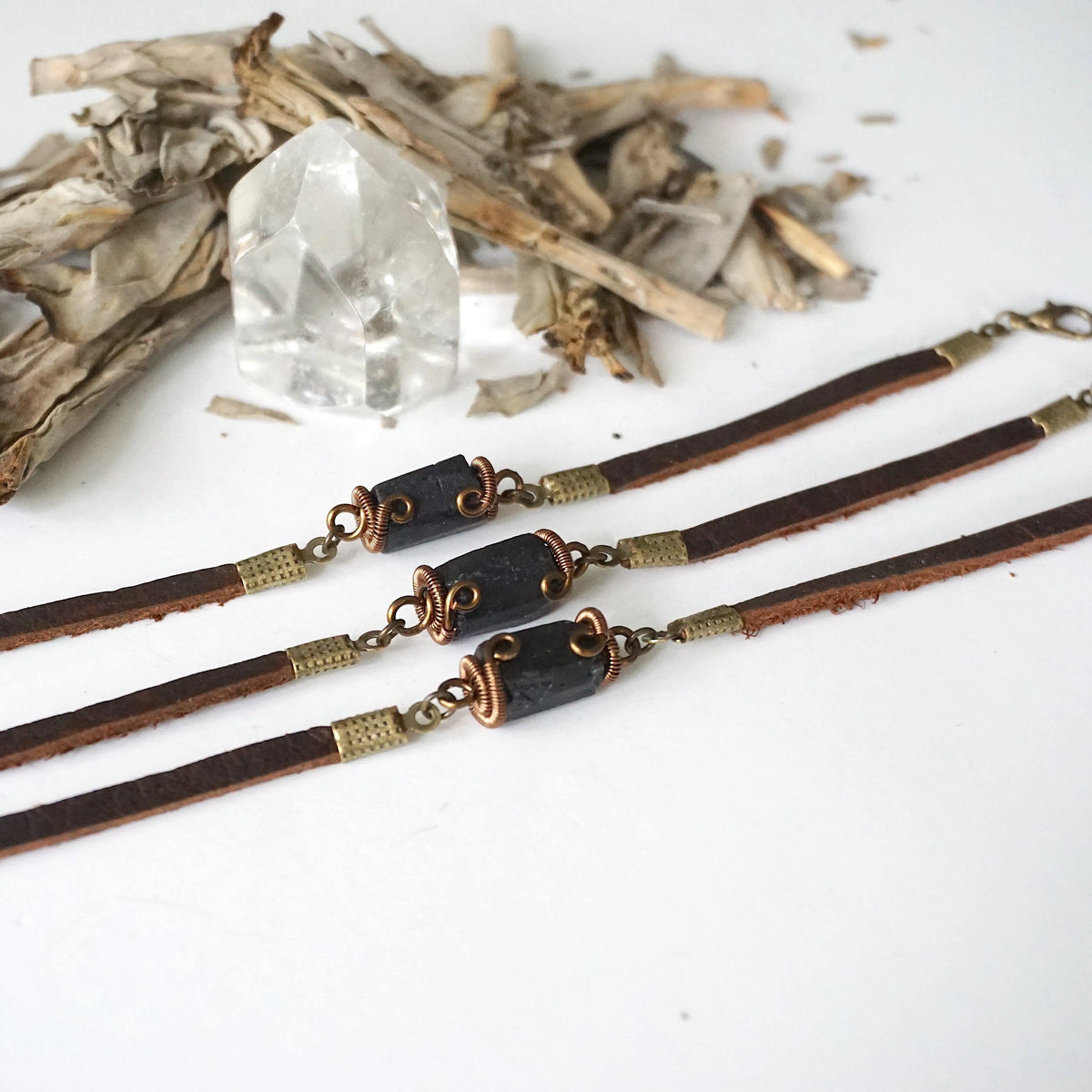 Three black tourmaline leather bracelets side by side, showing how each natural stone differs