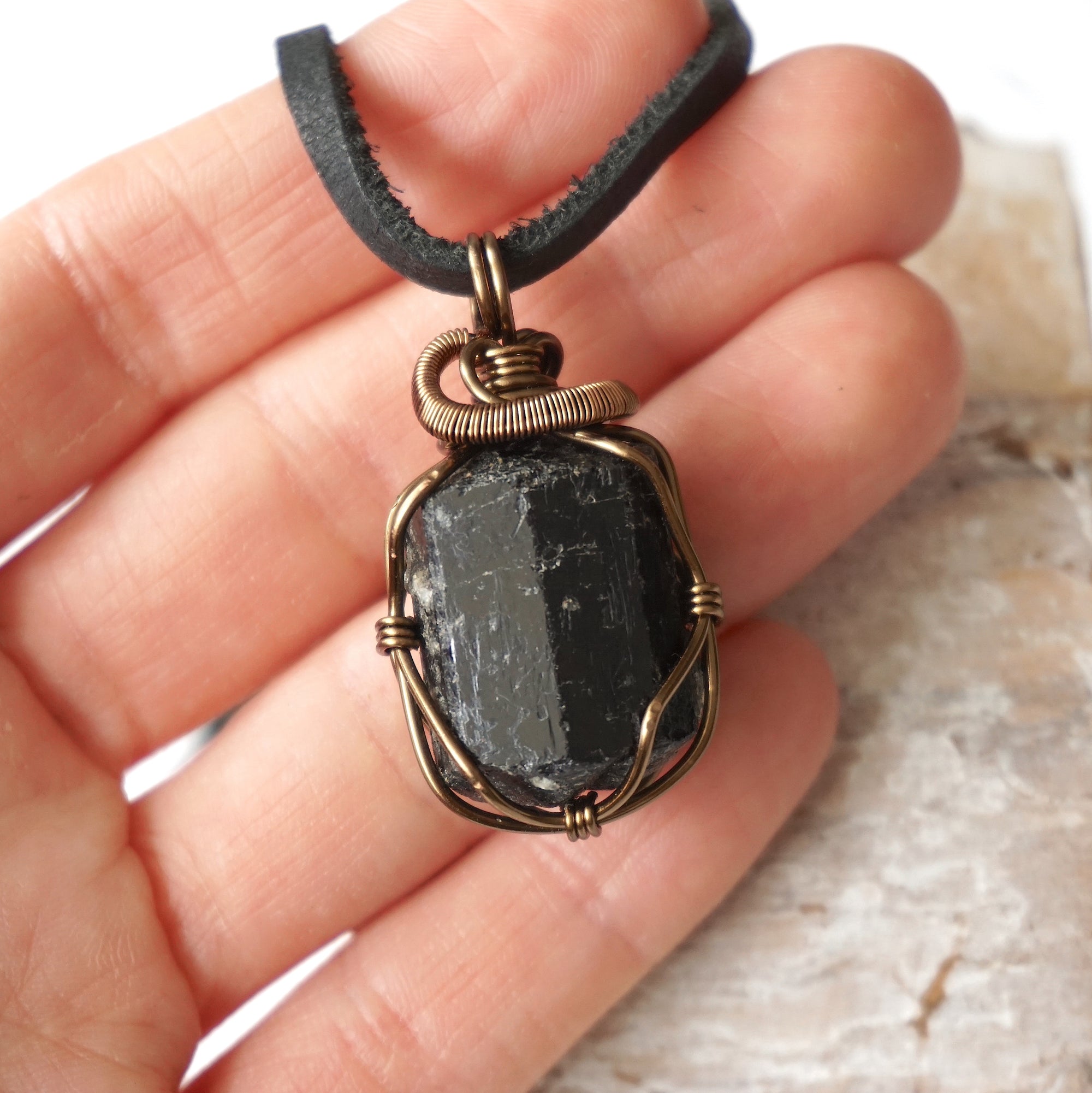 Raw black tourmaline necklace shown in hand for size reference, artisan jewelry by Designs by Nature Gems.