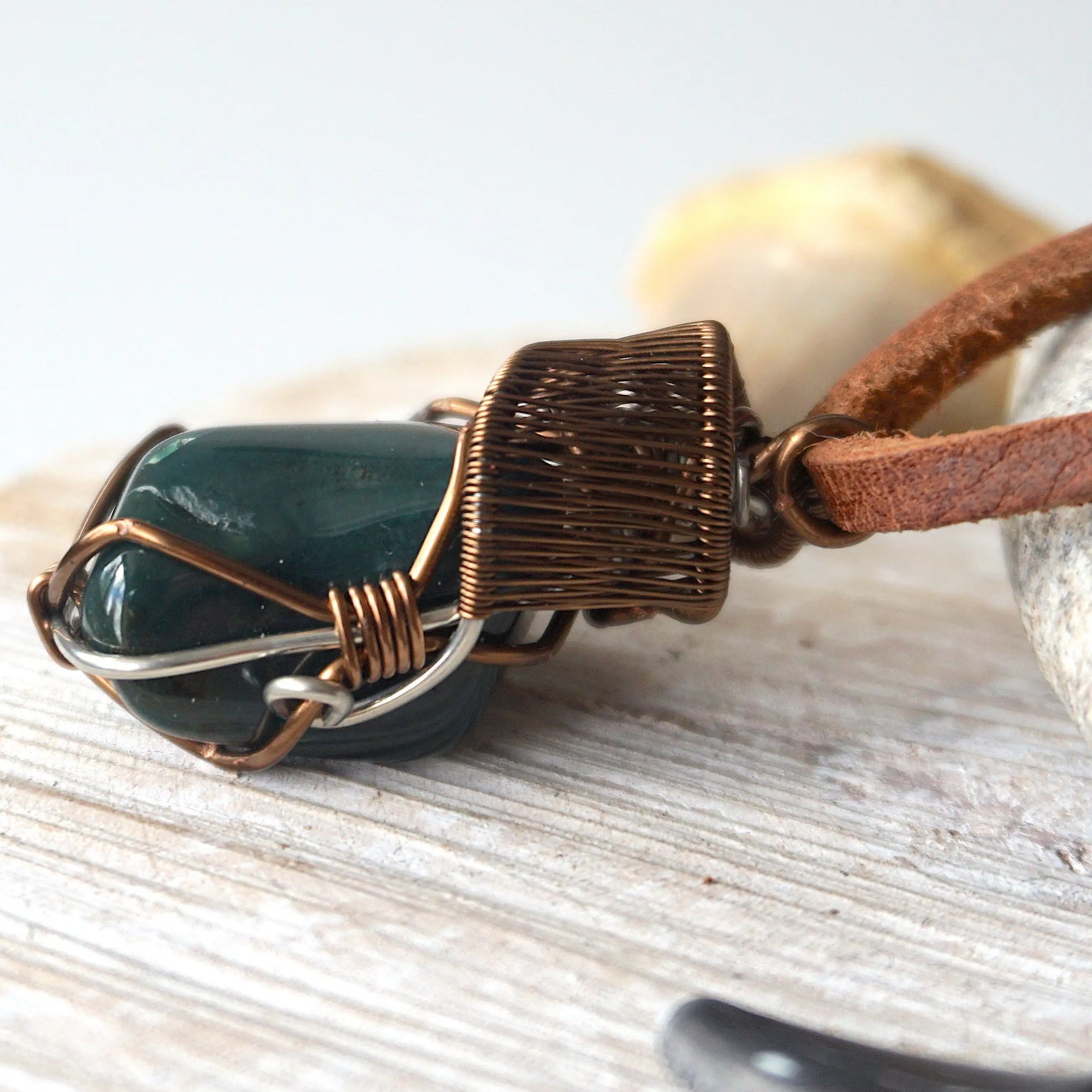 Close-up of artisan wire wrapping on natural bloodstone necklace, handcrafted by Designs by Nature Gems.