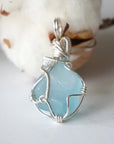 Back of a blue topaz pendant showing the hand wire-wrapped sterling silver pattern