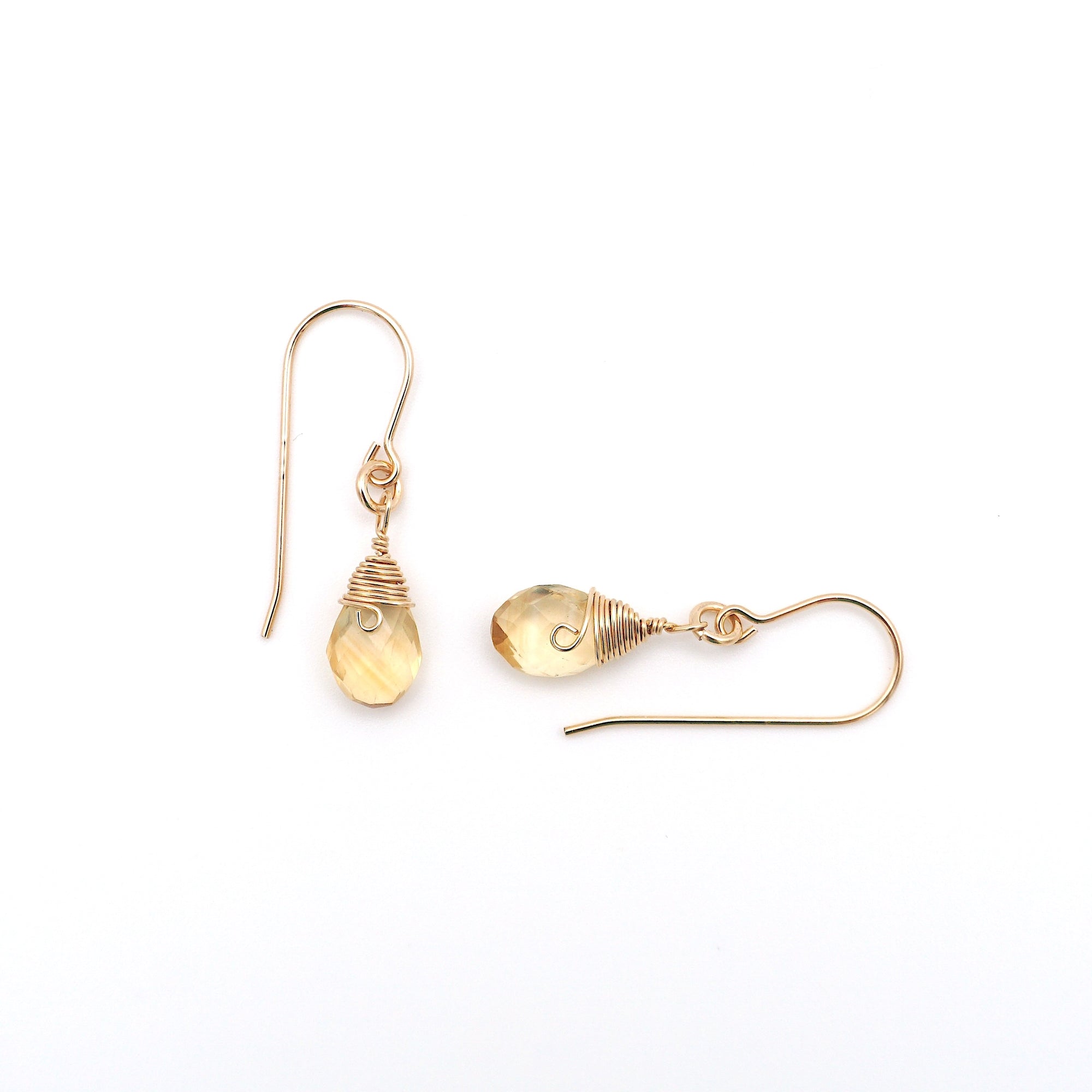 Closeup showing details of citrine drop earrings, faceted citrine stone, 14k gold filled setting