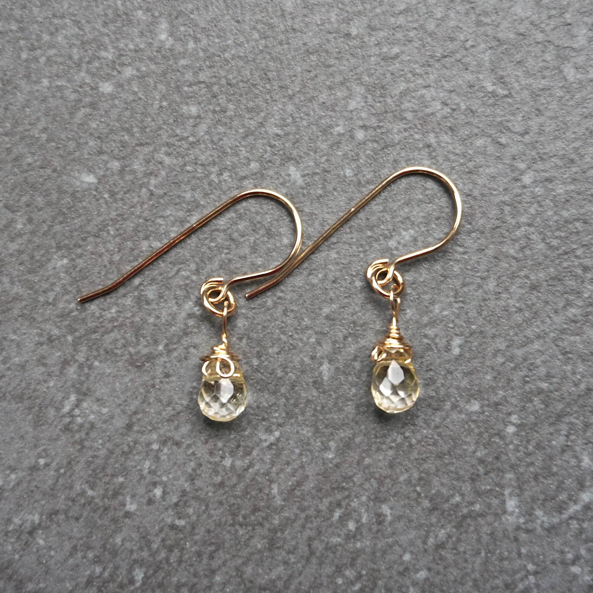 Close up detail of natural citrine crystal wire wrapped in 14k gold filled metal - handmade drop earrings showing artisan craftsmanship and golden stone