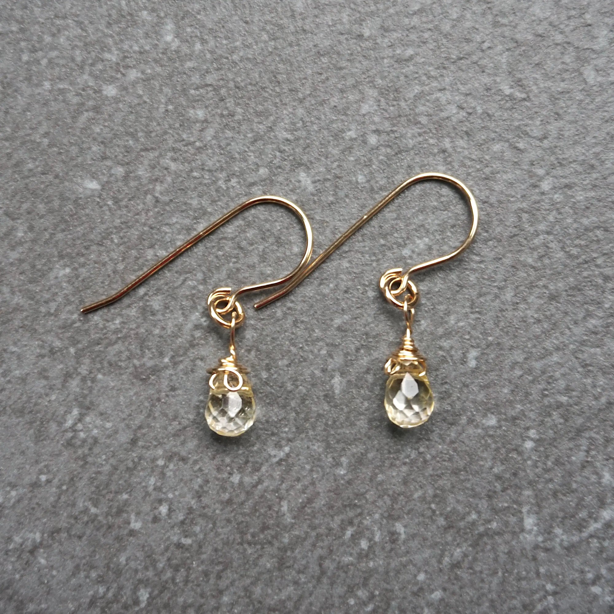 Close up detail of natural citrine crystal wire wrapped in 14k gold filled metal - handmade drop earrings showing artisan craftsmanship and golden stone