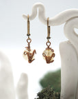 Close-up of handcrafted citrine drop earrings with antique bronze copper wire wrapping.