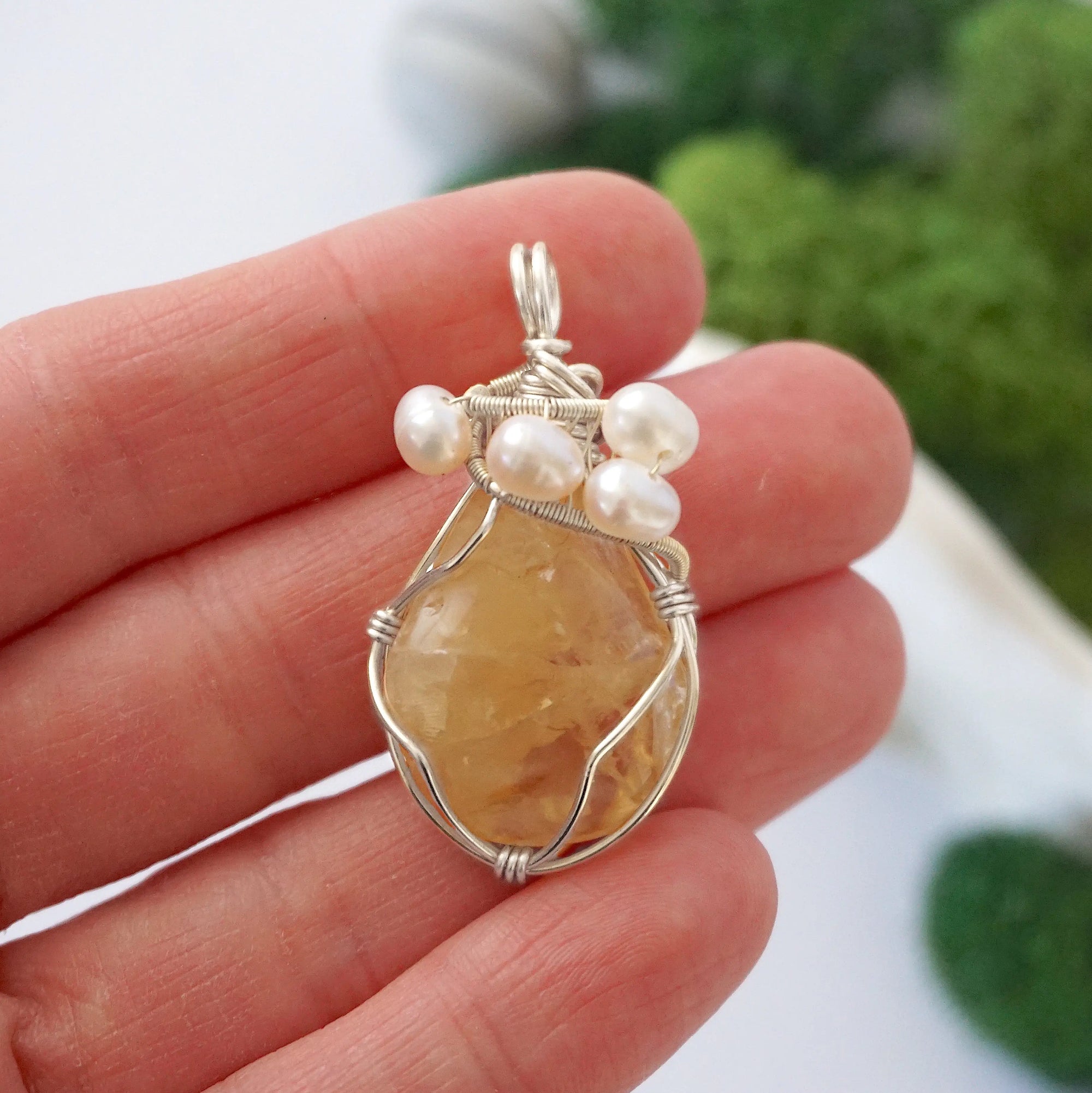 Citrine and freshwater pearl pendant necklace in hand for size reference, silver wire wrapped, handcrafted gemstone jewelry