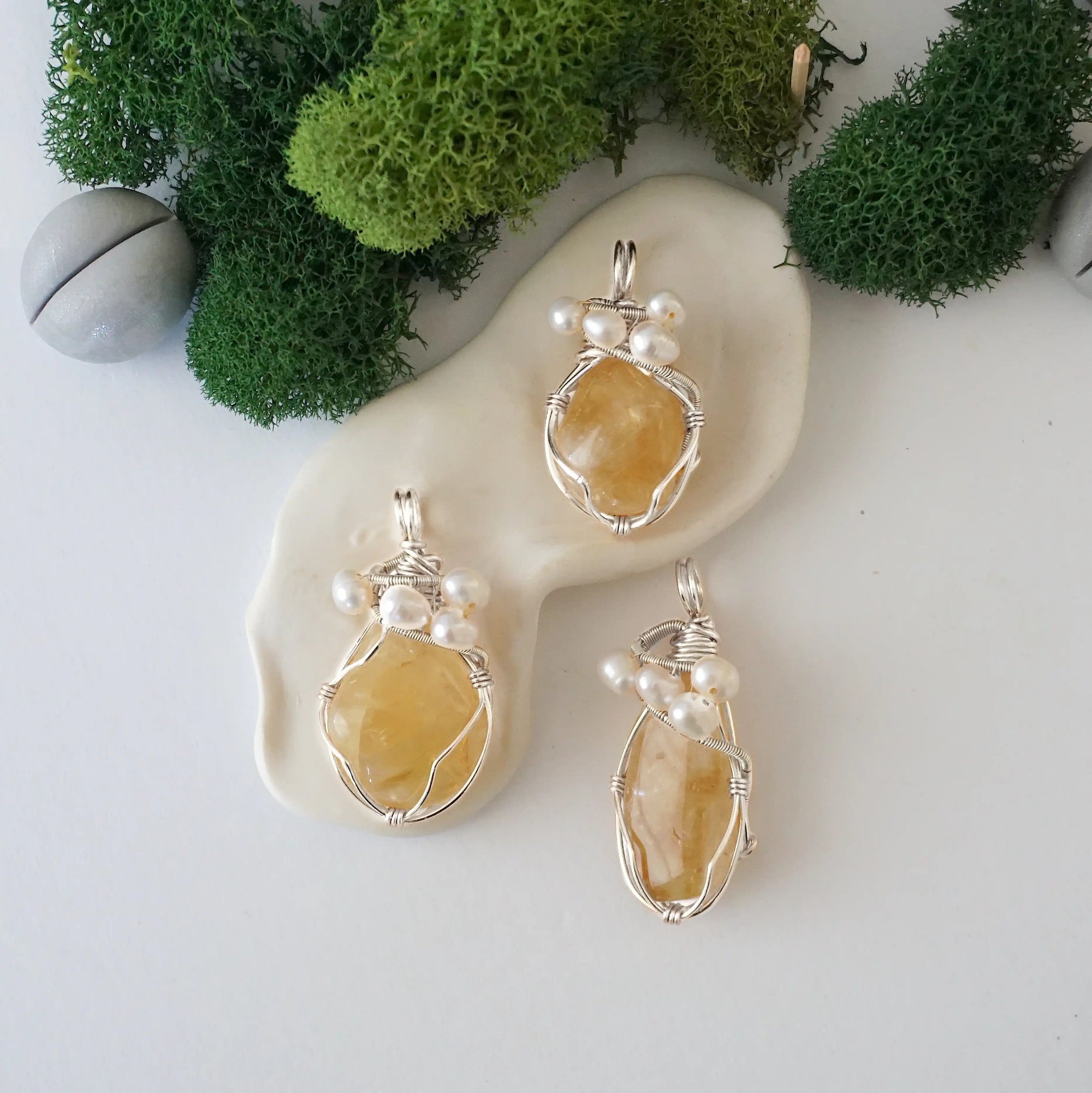 Three silver wire wrapped citrine and freshwater pearl pendants showing natural stone variation, artisan jewelry for women