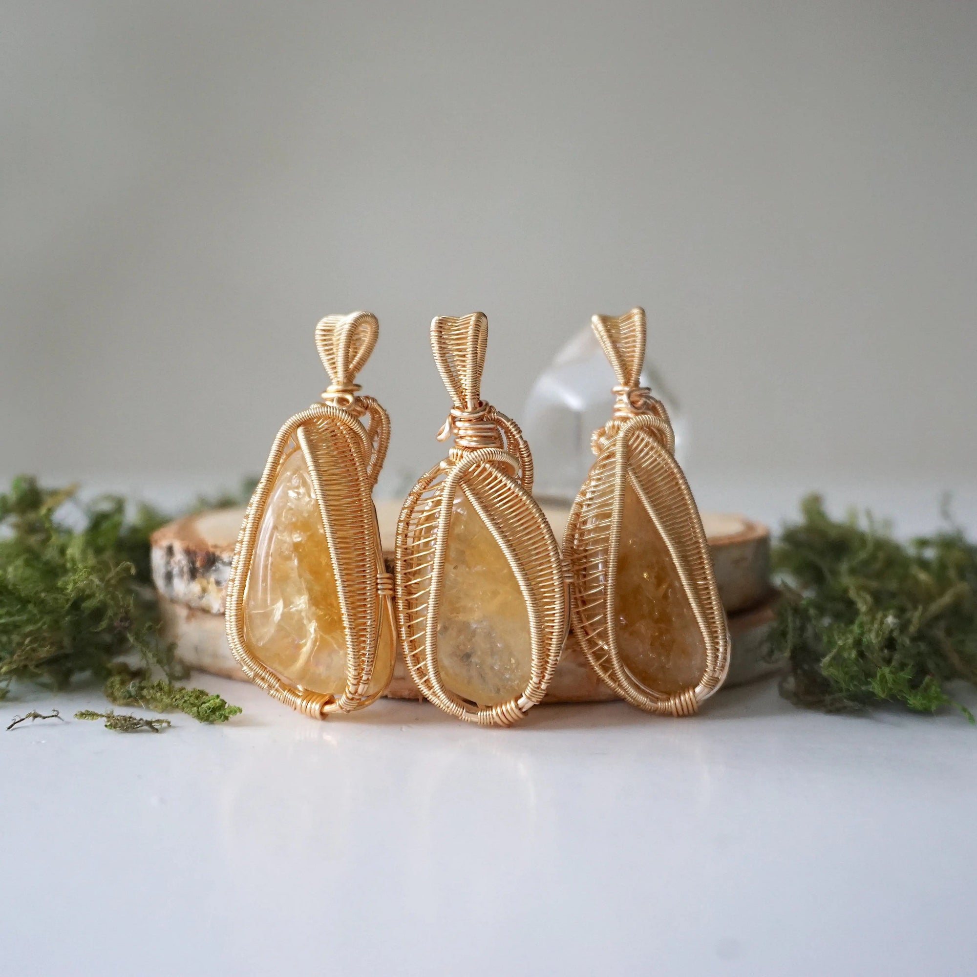 Three citrine necklaces gold wire wrapped showing polished stone size shape and color variation November birthstone options
