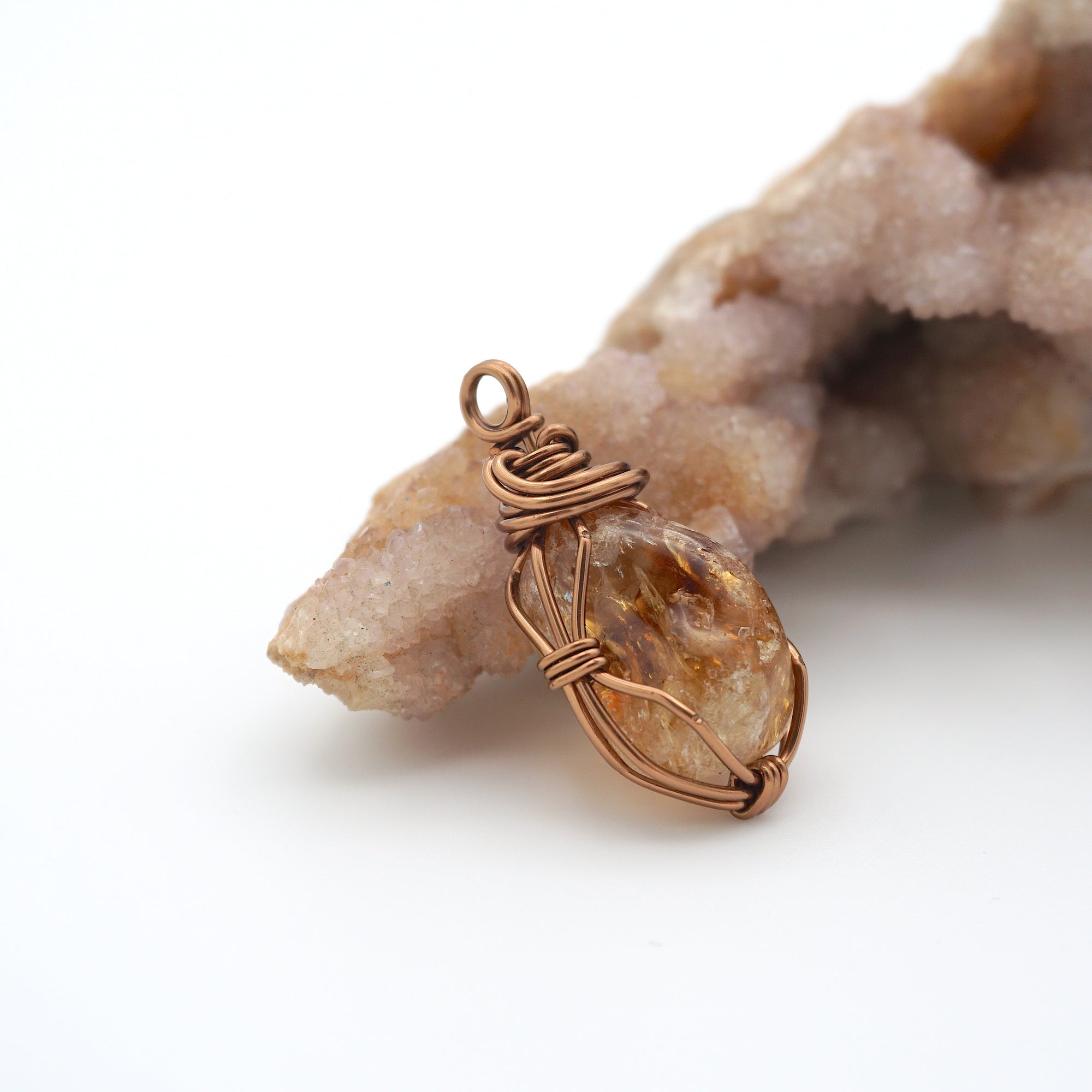 Side view of raw citrine pendant necklace displaying wire wrapping technique in antique bronze copper metal