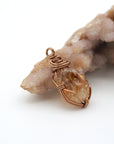 Side view of raw citrine pendant necklace displaying wire wrapping technique in antique bronze copper metal