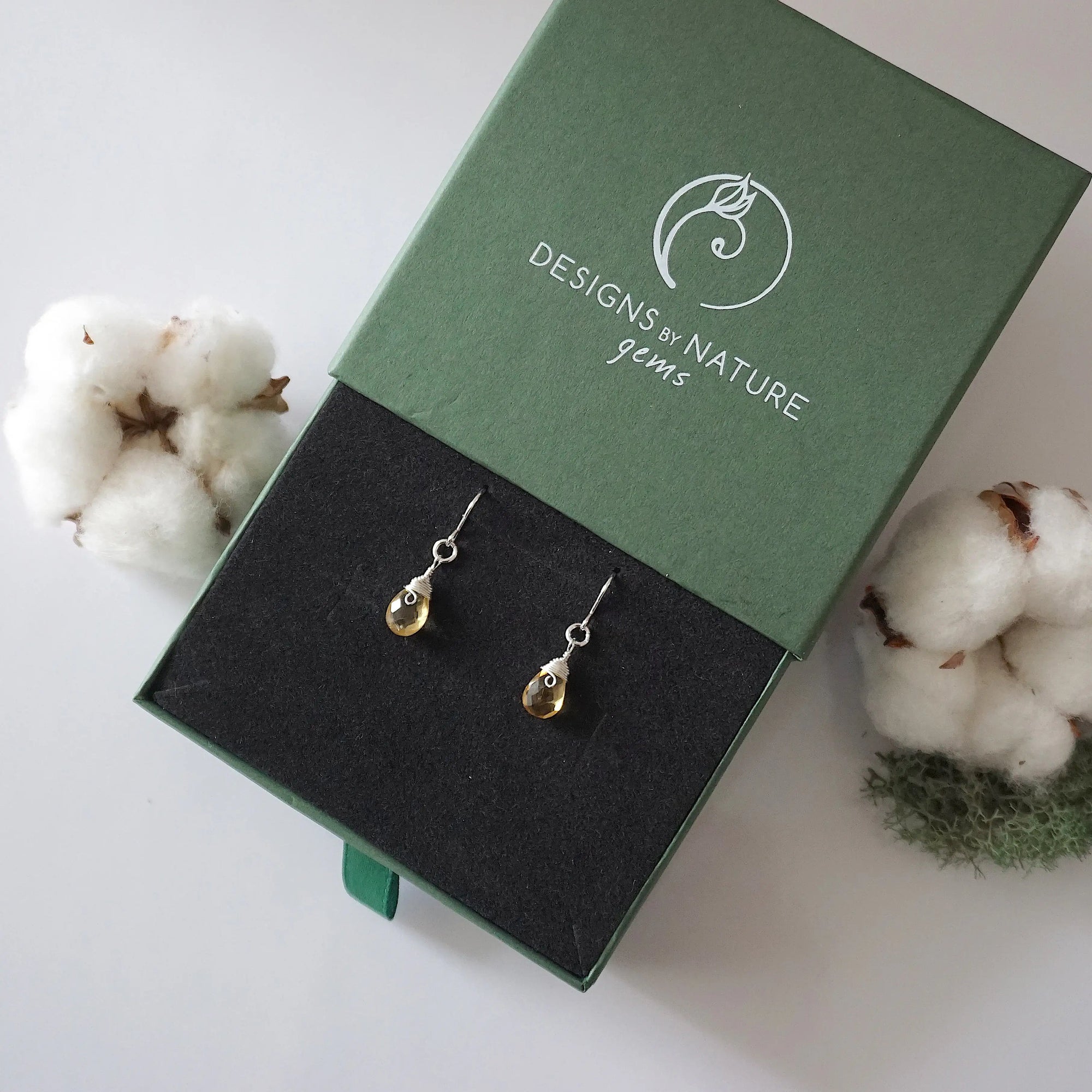 Citrine sterling silver drop earrings in branded Designs by Nature Gems jewelry box, showcasing handcrafted faceted citrine and sterling silver wire wrapping