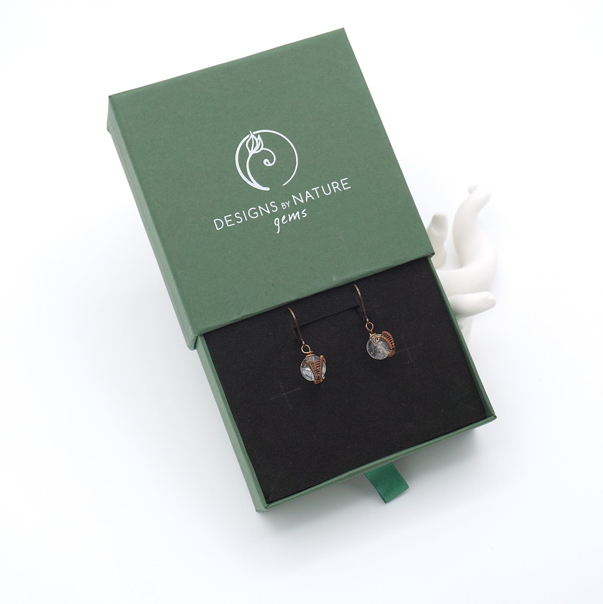 Clear quartz drop earrings presented in a branded gift box, ready for gifting, with antique bronze copper wire wrapping.