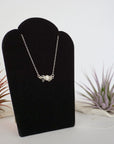 Right angle view of clear quartz and freshwater pearl bar necklace in 925 sterling silver on jewelry display