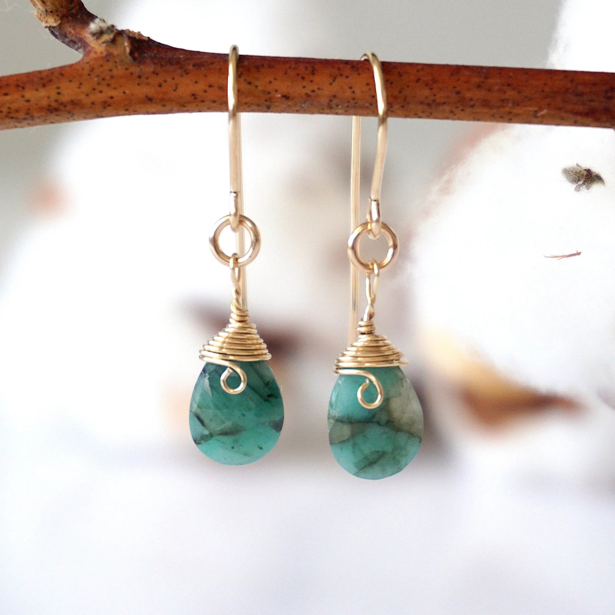 Detailed front view of emerald drop earrings, genuine faceted emerald with minimalist 14k gold filled wire wrapping, Designs by Nature Gems

