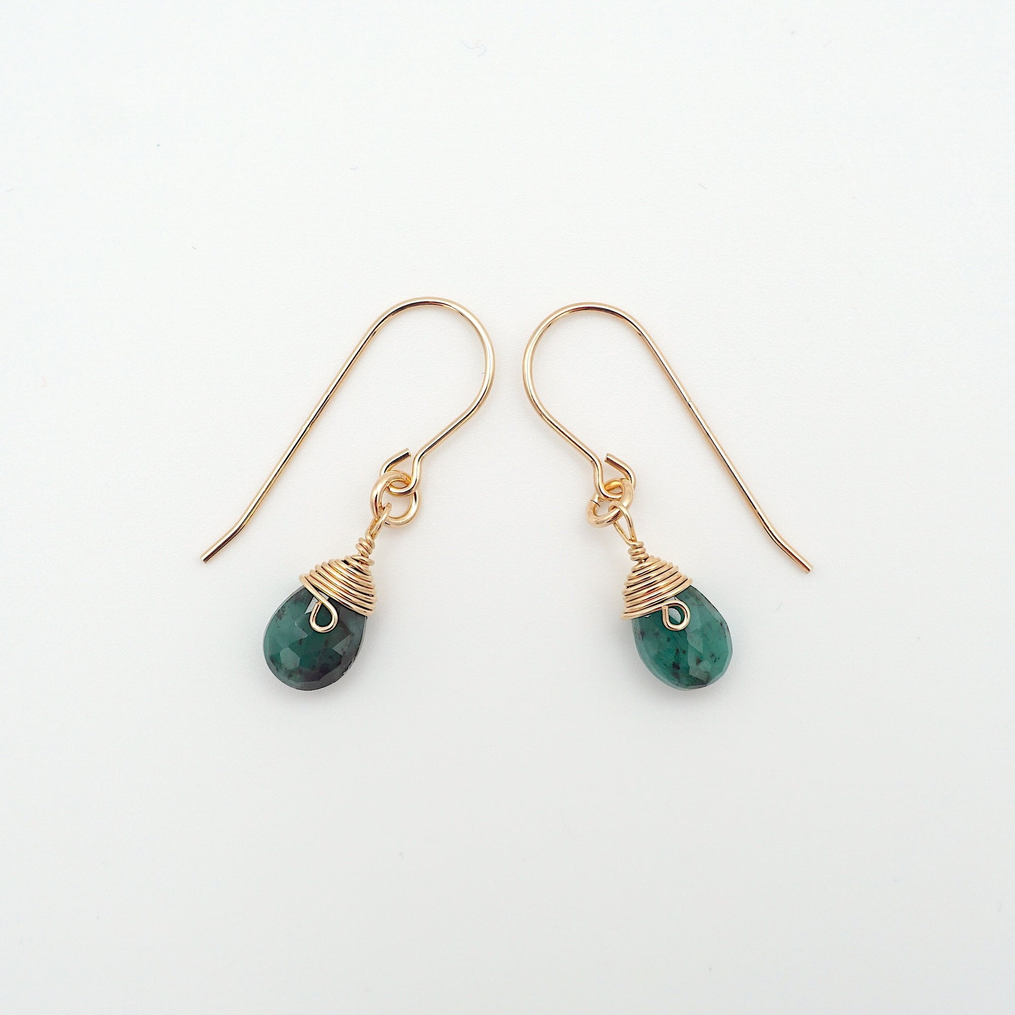 Side angle of emerald drop earrings, minimalist artisan wire wrapping, 14k gold filled
