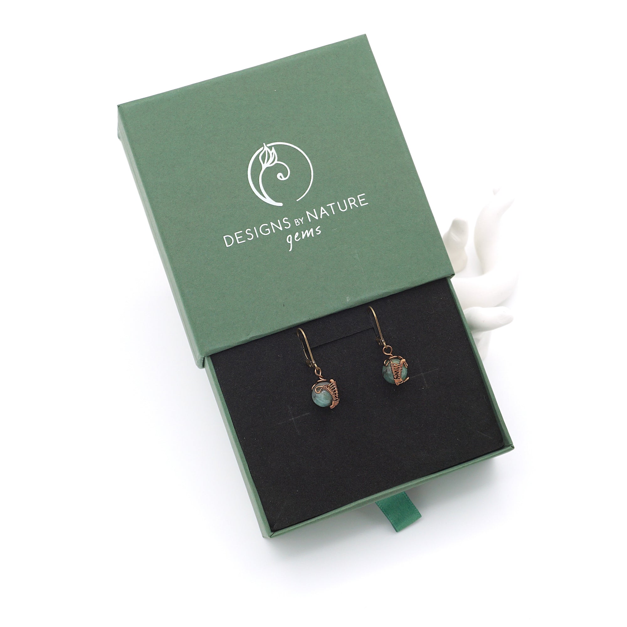Emerald drop earrings presented in a branded gift box, ready for gifting, with antique bronze copper wire wrapping.