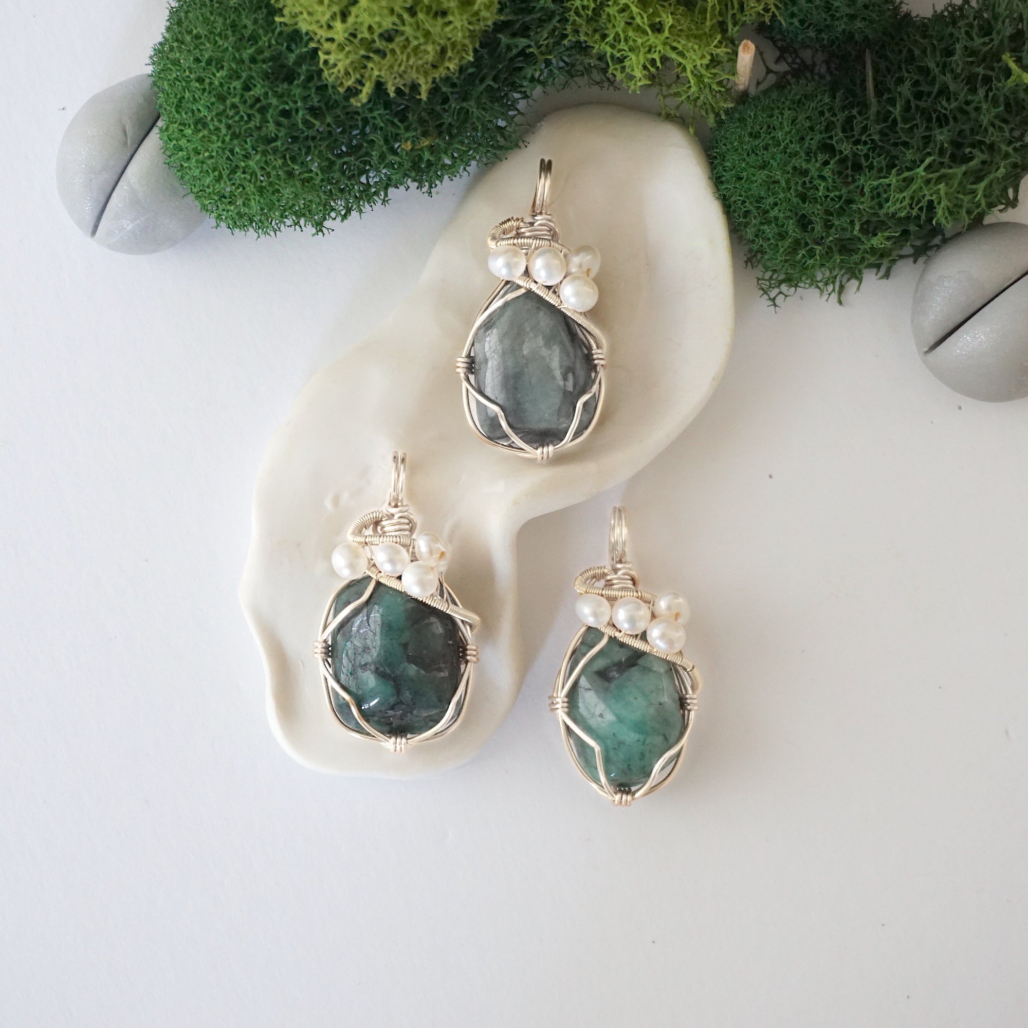 Three silver wire wrapped emerald and freshwater pearl pendants showing natural stone variation, artisan jewelry for women