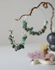 Close-up of emerald hoop earrings showing natural emerald chips and artisan wire wrapping in soft silver copper