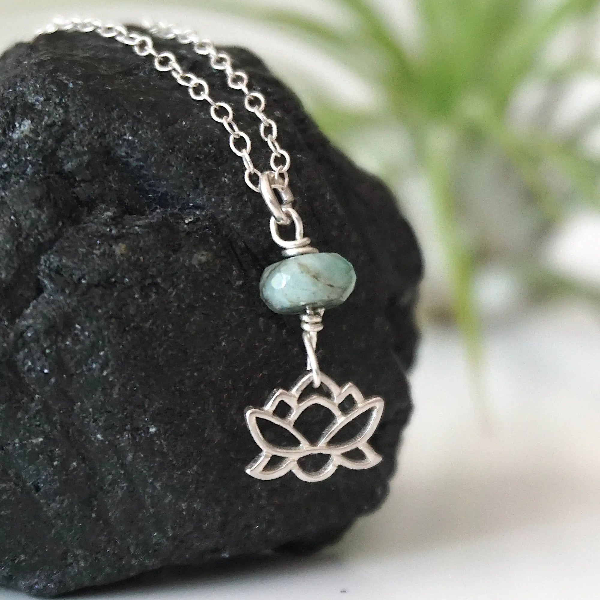 Right angle detail of emerald and lotus necklace for women with faceted emerald bead and artisan sterling silver lotus design