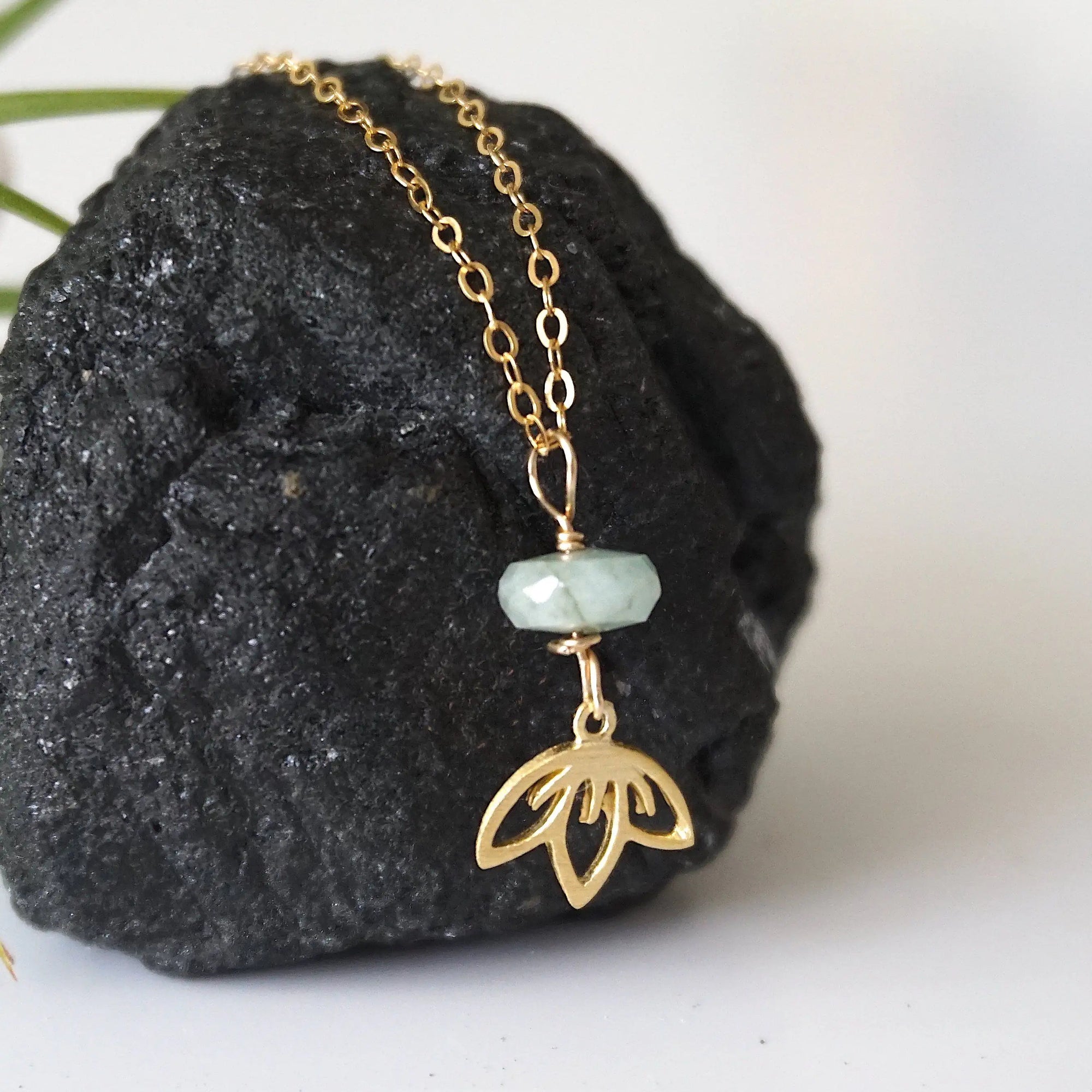 Right angle detail of emerald and lotus necklace for women with faceted emerald bead and artisan gold vermeil lotus design