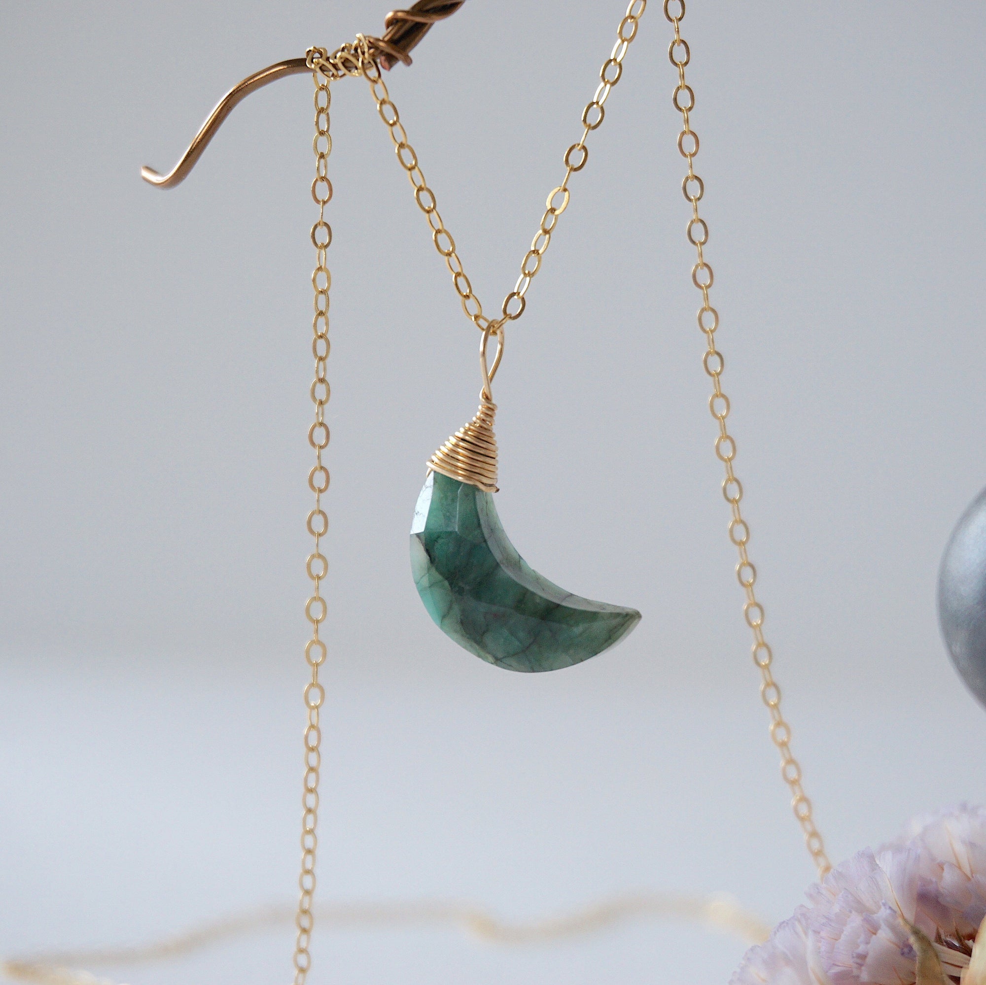 Left angle detail of faceted emerald moon necklace for women with classic artisan 14k gold filled wrapping