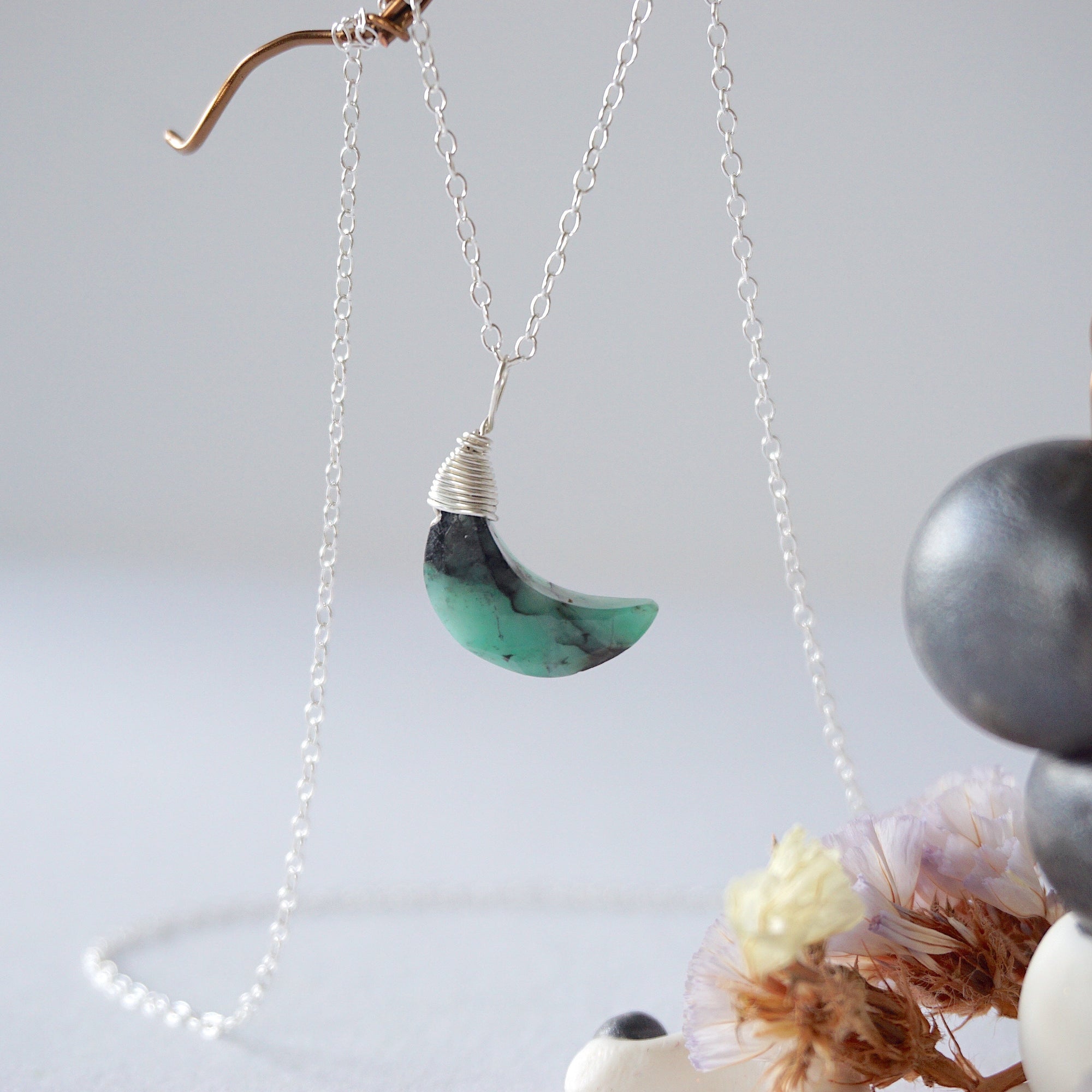 Left angle detail of faceted emerald moon necklace for women with classic artisan 925 sterling silver wrapping