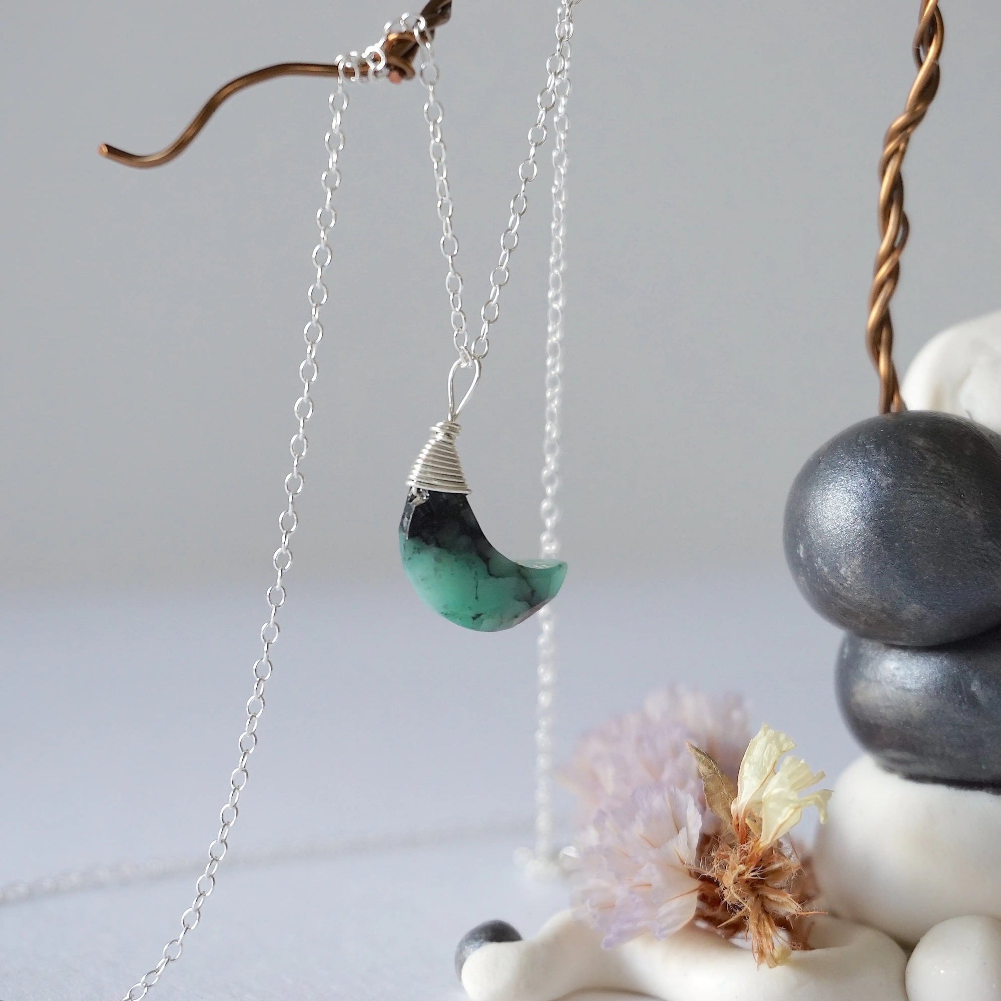 Right angle detail of emerald moon necklace for women with natural faceted emerald and handcrafted sterling silver wire wrapping